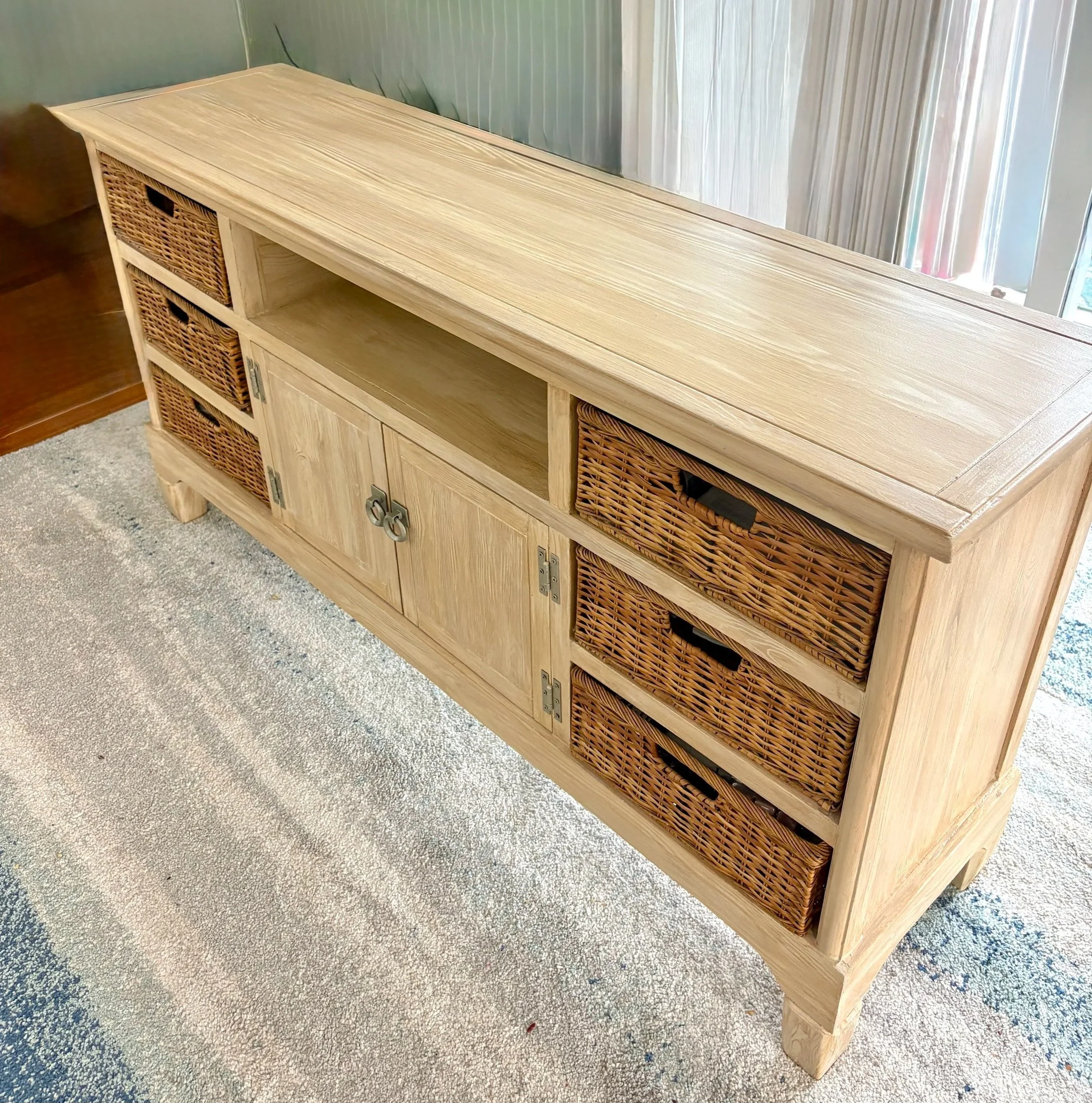 A perfect example of what paint can do! An off white laminate in need of creative TLC painted to look like wood, bringing a more coastal feel to room!
