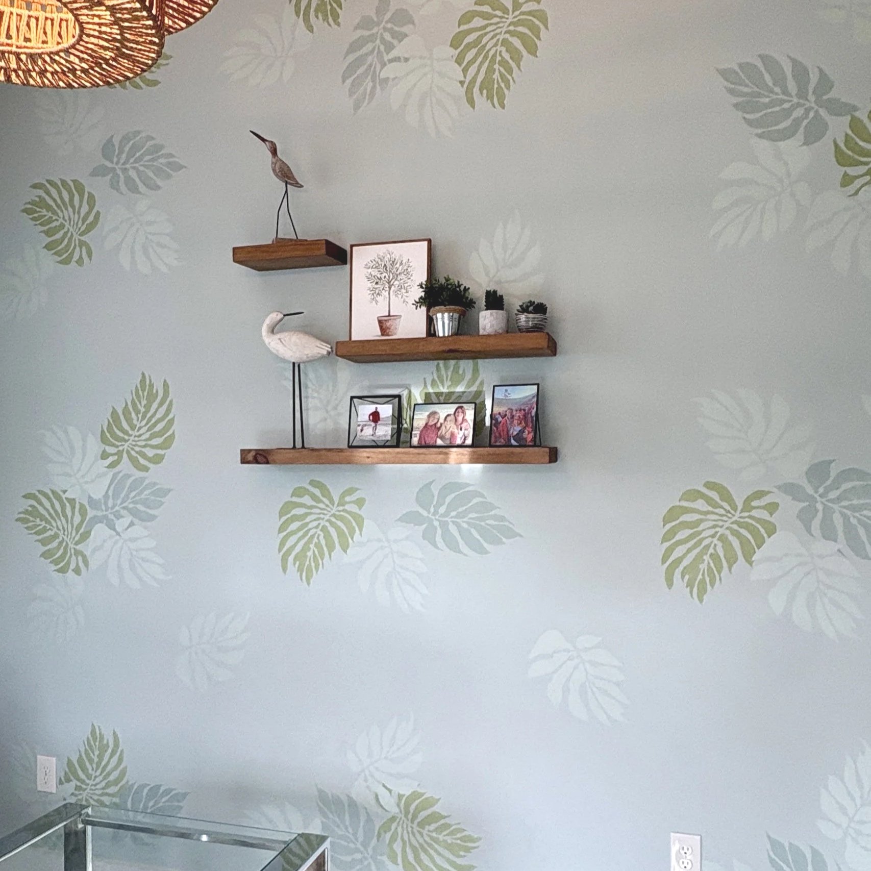 Detail of large stenciled tropical leaves done in shades of green