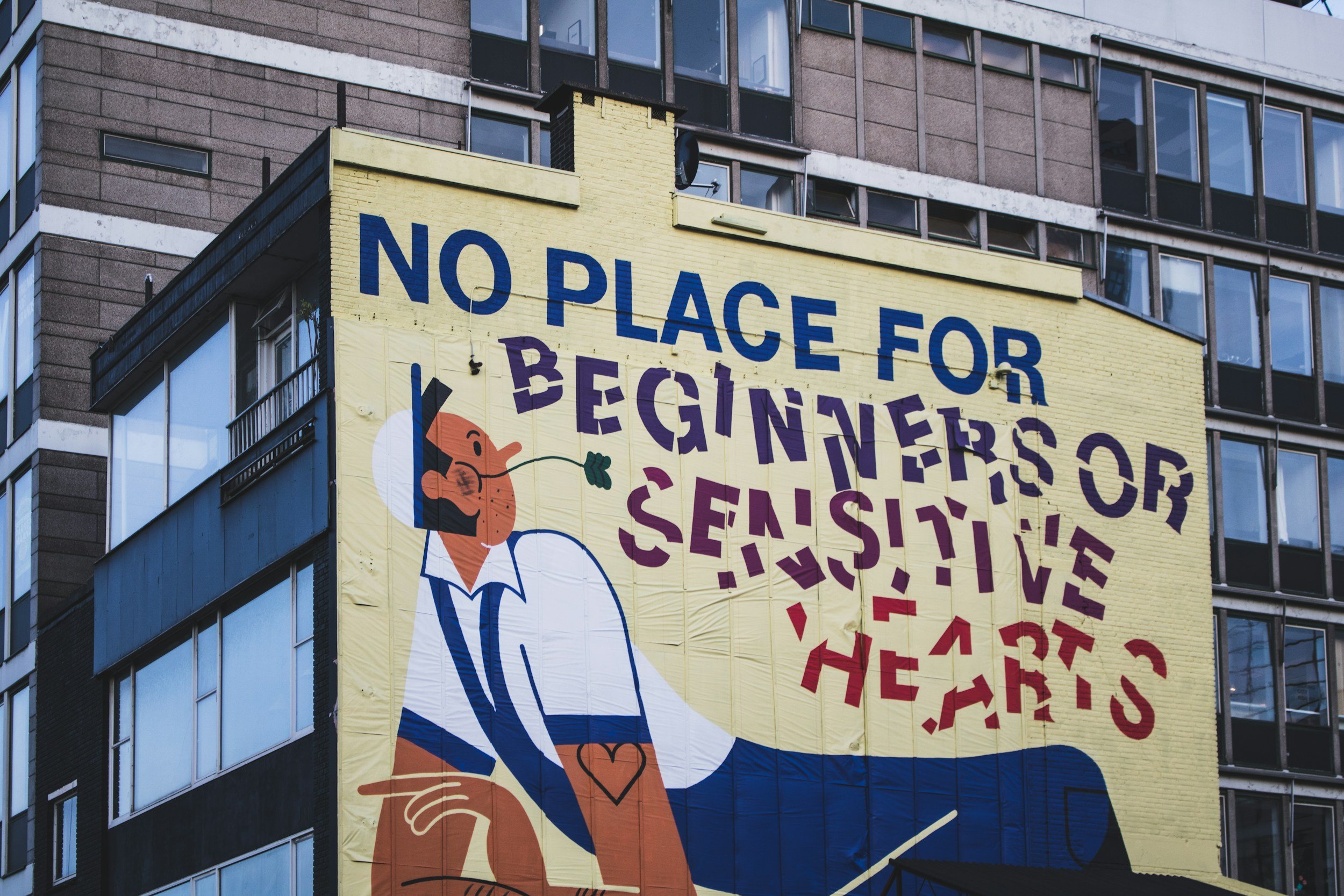 Mural on the wall of a worker resting that states: "No place for beginners or sensitive hearts"