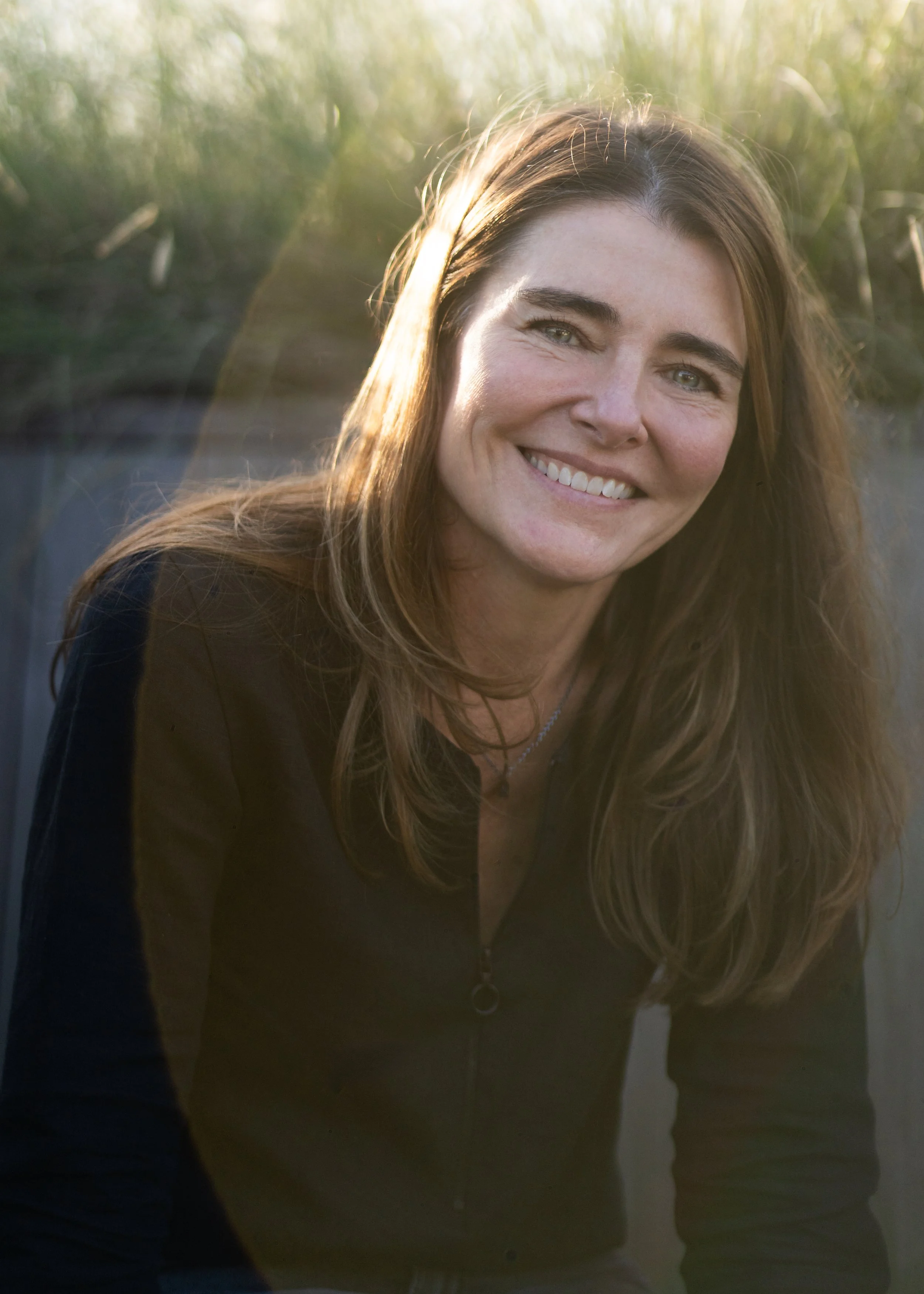 A photo of a smiling woman with long hair.