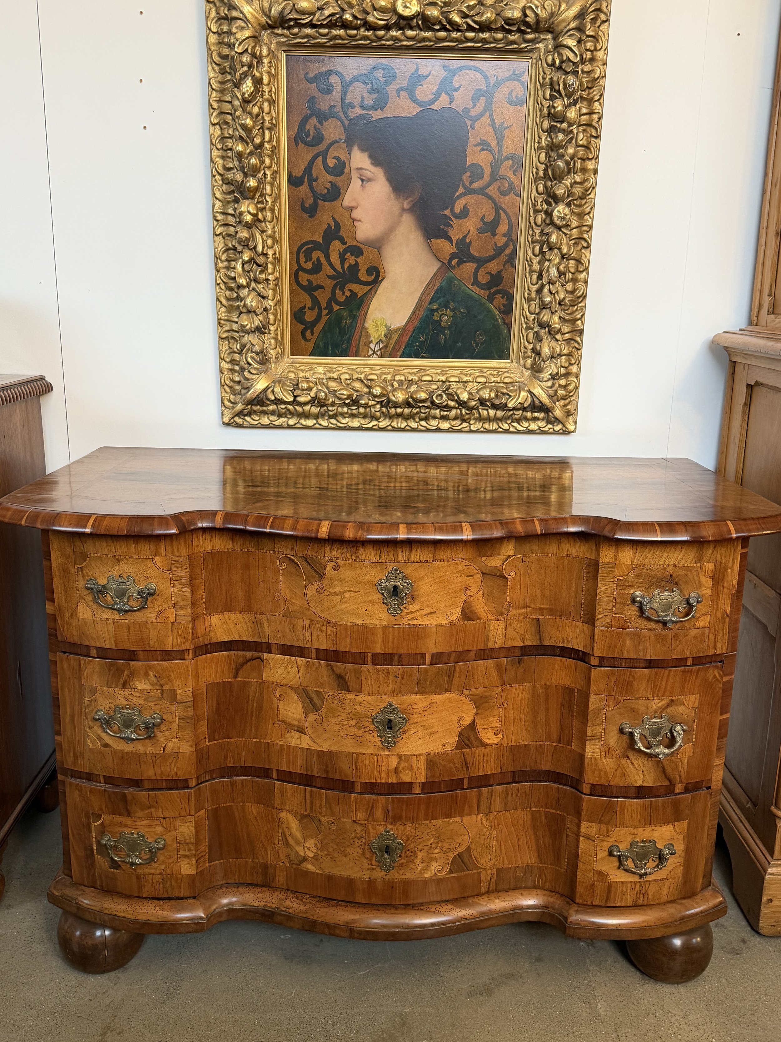 This is a picture of an antique mid 18th century German walnut and fruitwood serpentine fronted three drawer commode c1760.