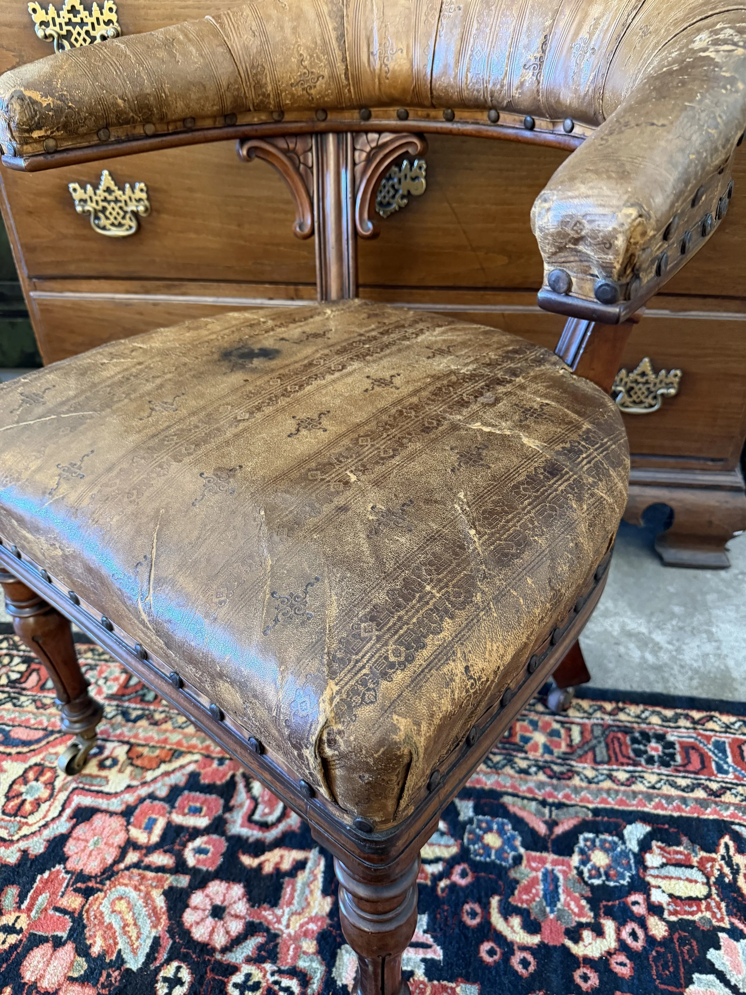 This is a picture of a very handsome and comfortable Victorian mahogany desk chair retaining its original stamped leather upholstery c1870.