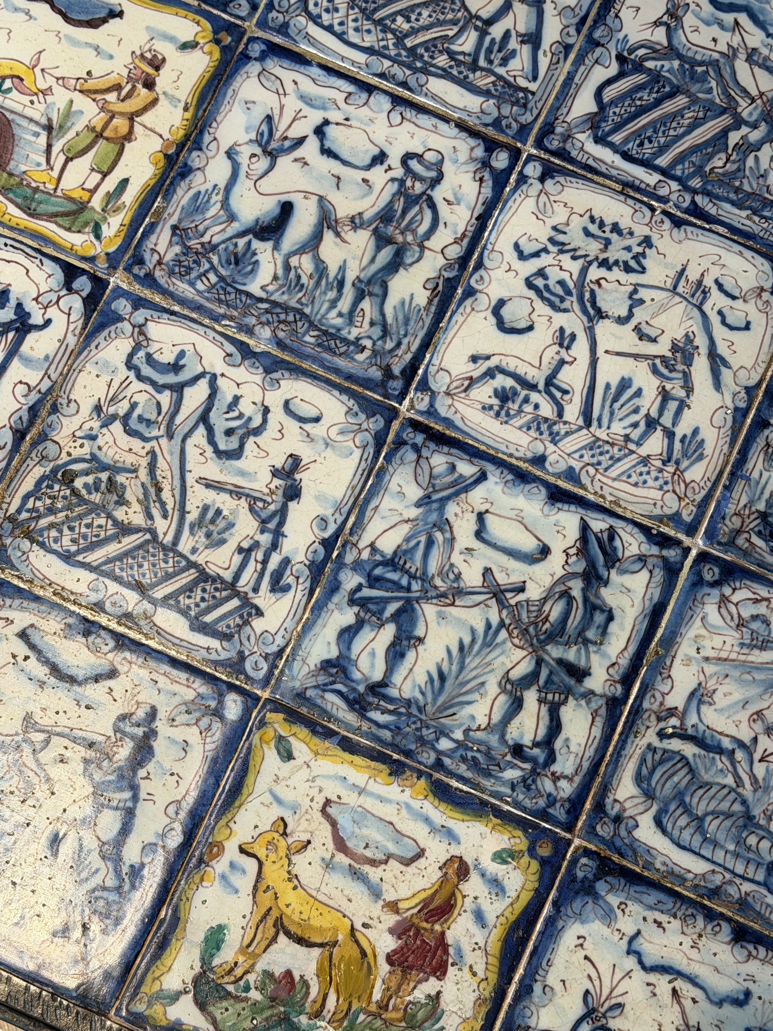 This is a picture of a panel of 20 wonderful 18th century Spanish tiles set into a mid 20th century wrought iron coffee table base.
