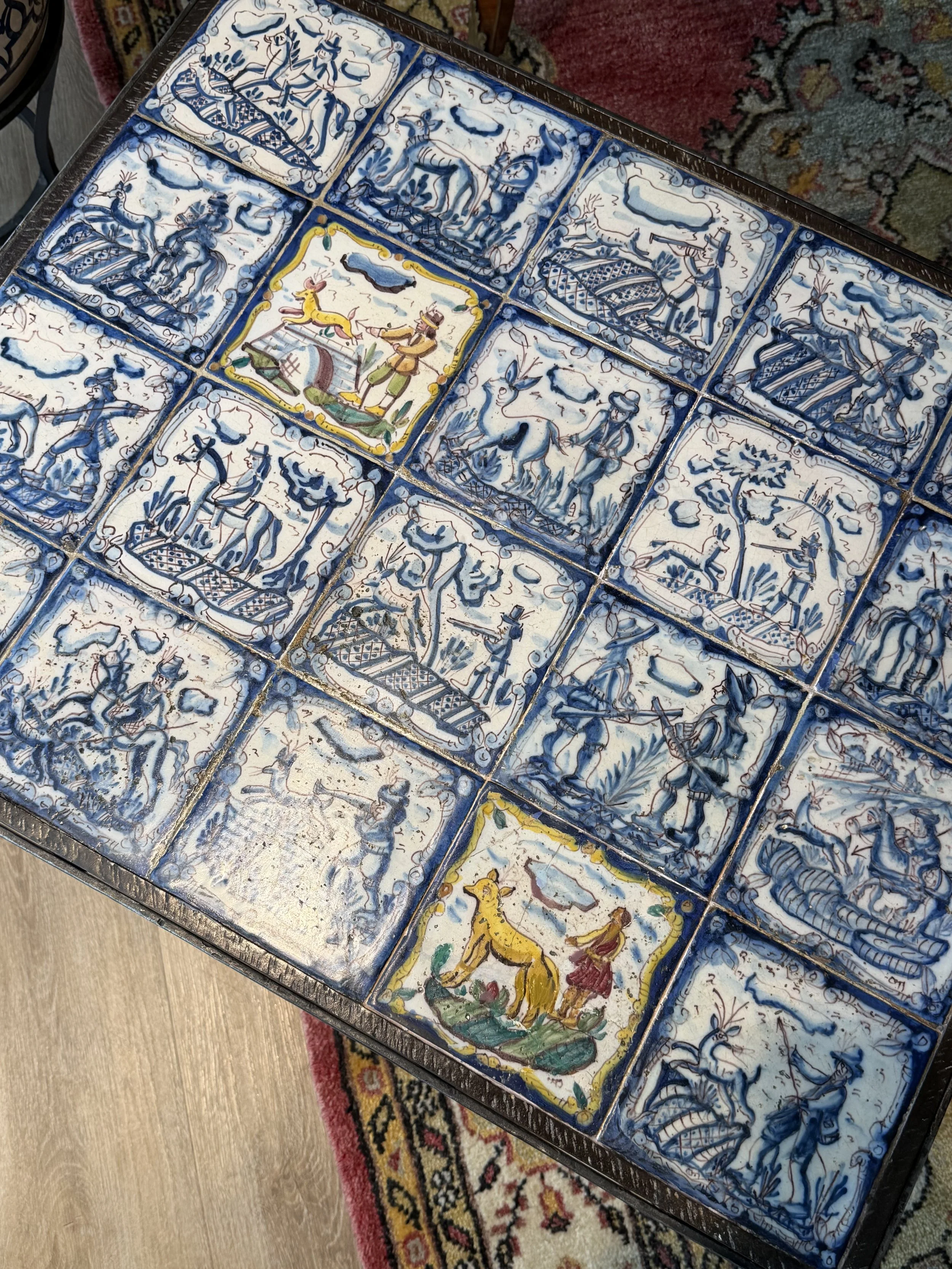 This is a picture of a panel of 20 wonderful 18th century Spanish tiles set into a mid 20th century wrought iron coffee table base.