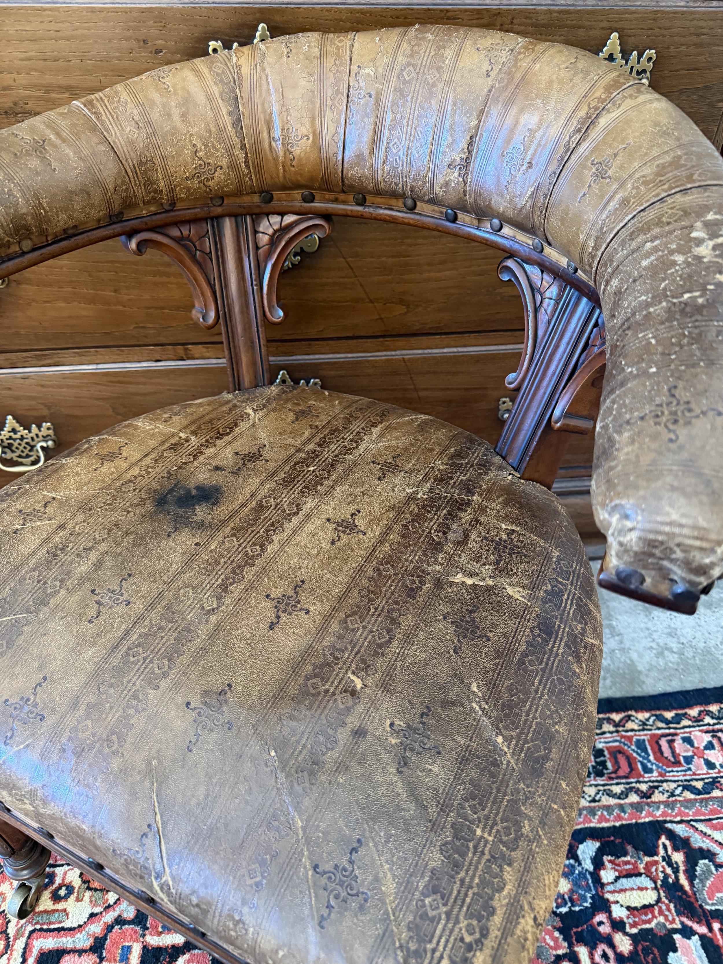 This is a picture of a very handsome and comfortable Victorian mahogany desk chair retaining its original stamped leather upholstery c1870.