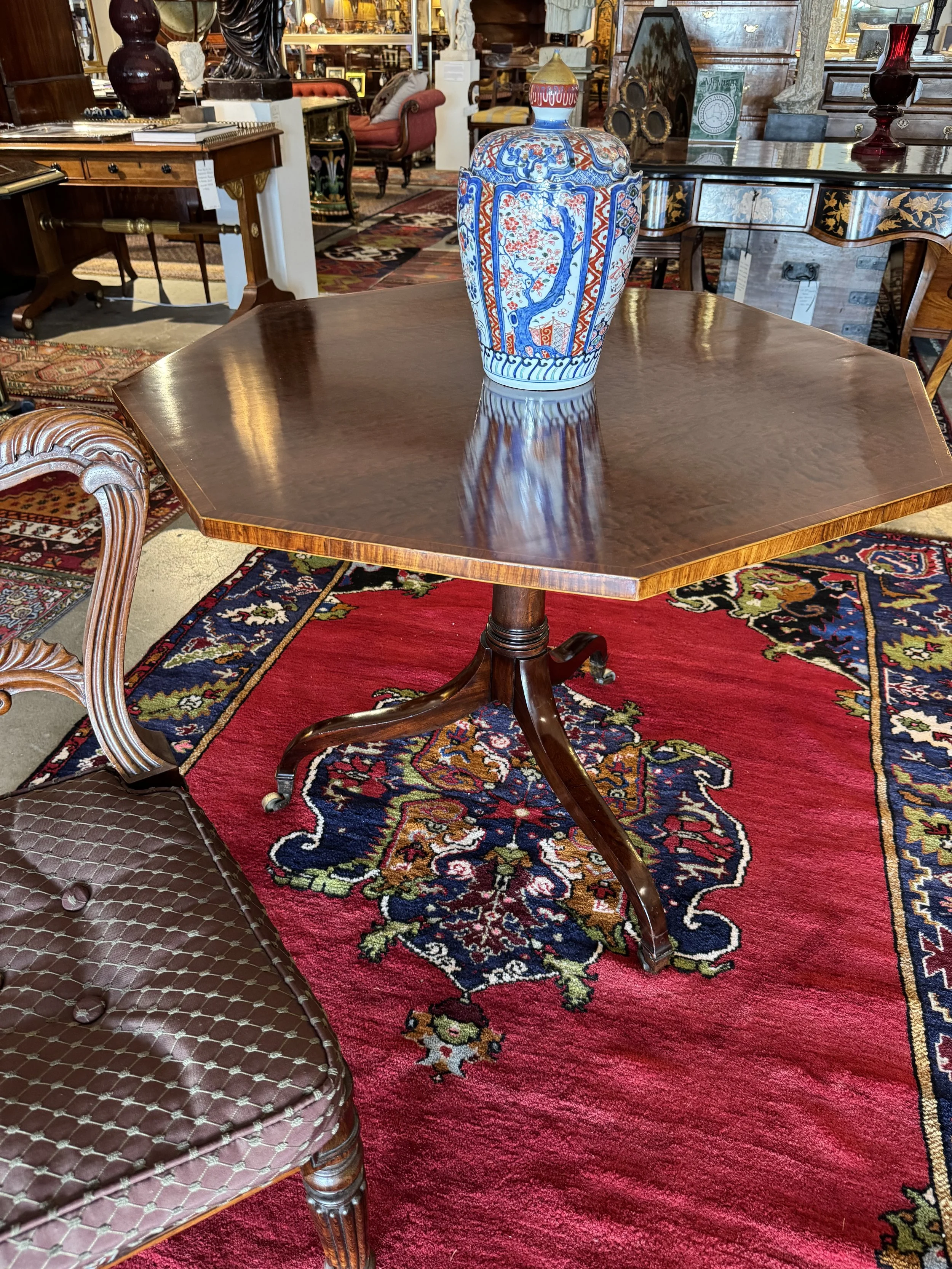 This is a picture of a superb English antique George III period octagonal plum pudding mahogany and rosewood cross banded centre table c1790.