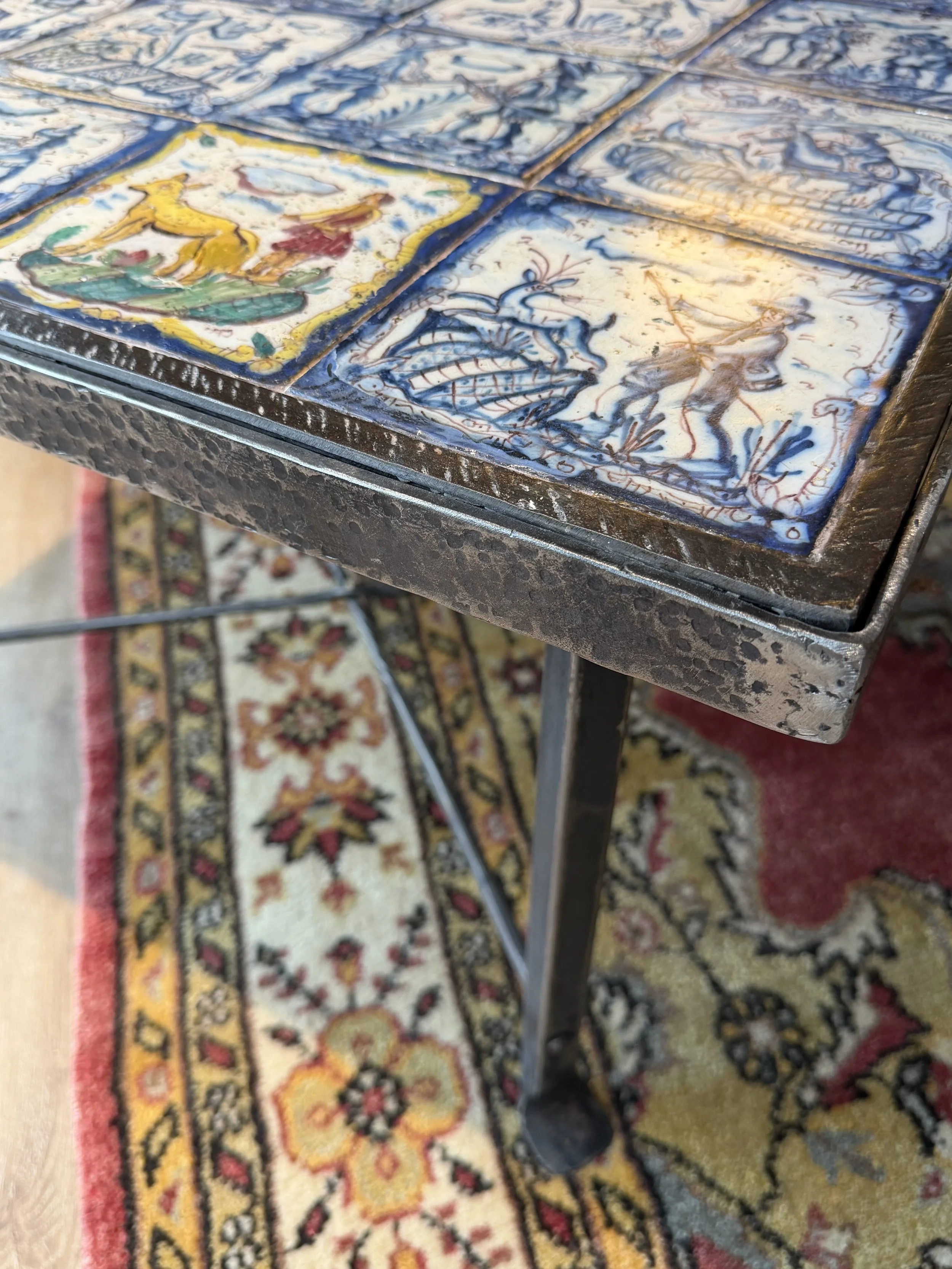 This is a picture of a panel of 20 wonderful 18th century Spanish tiles set into a mid 20th century wrought iron coffee table base.