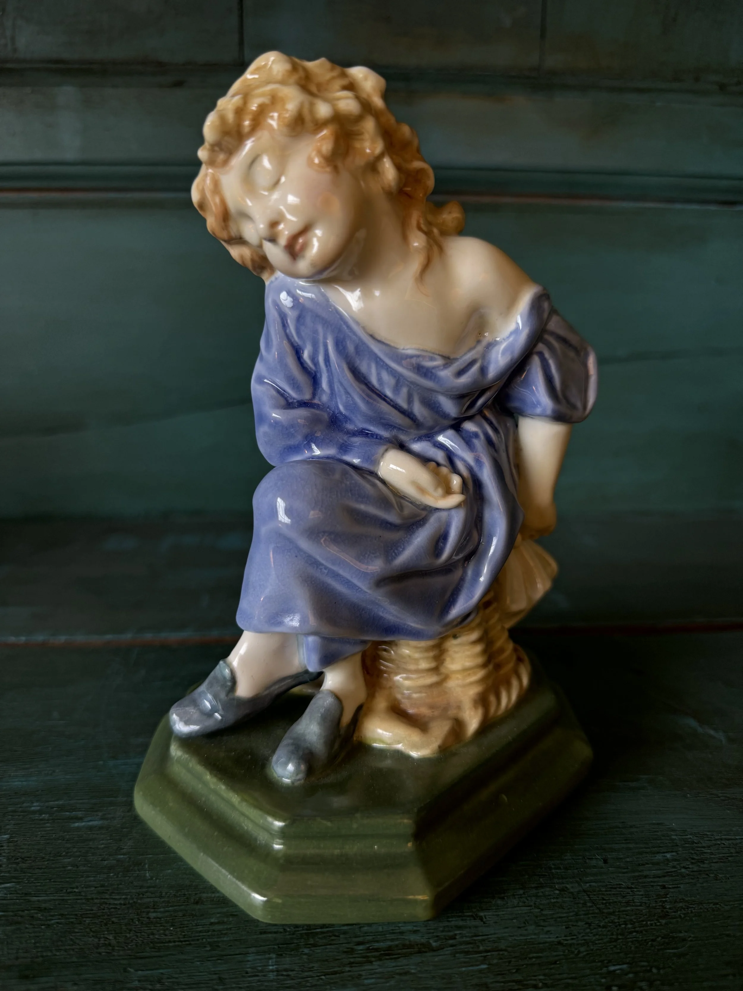 This is a picture of a charming figure designed by William White for Doulton &Co c1915 called The Sleepy Scholar in a rare colour way.