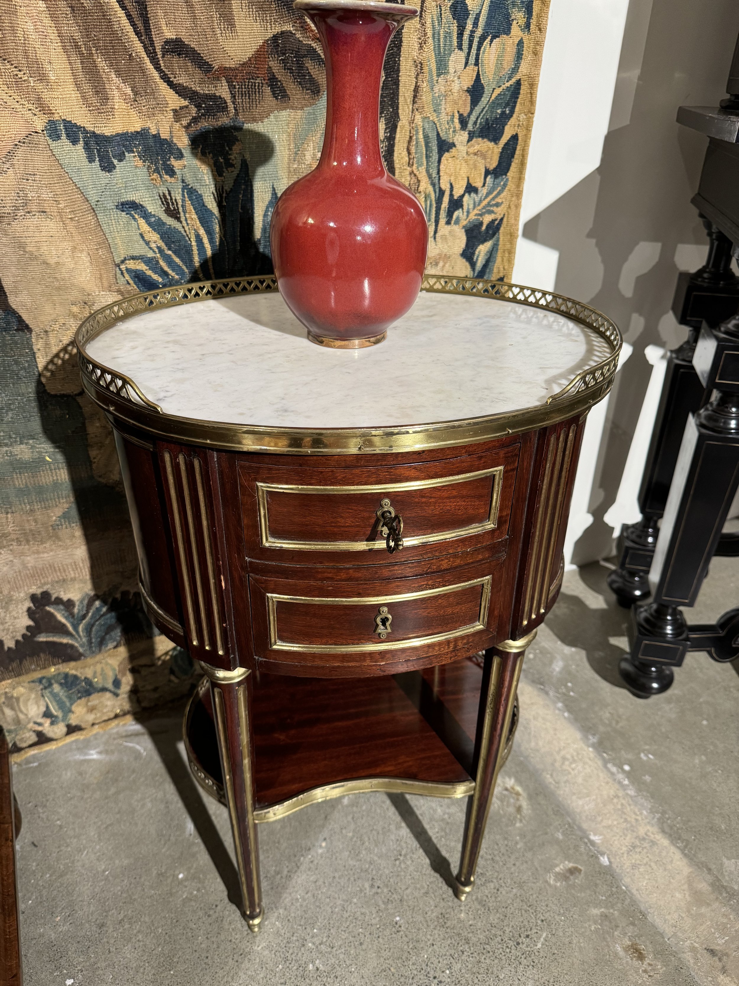 This is a picture of an antique French Louis XVI style ormolu mounted and marble topped gueridon c1880. With two drawers and a marble top it would make an excellent bedside table or occasional table.