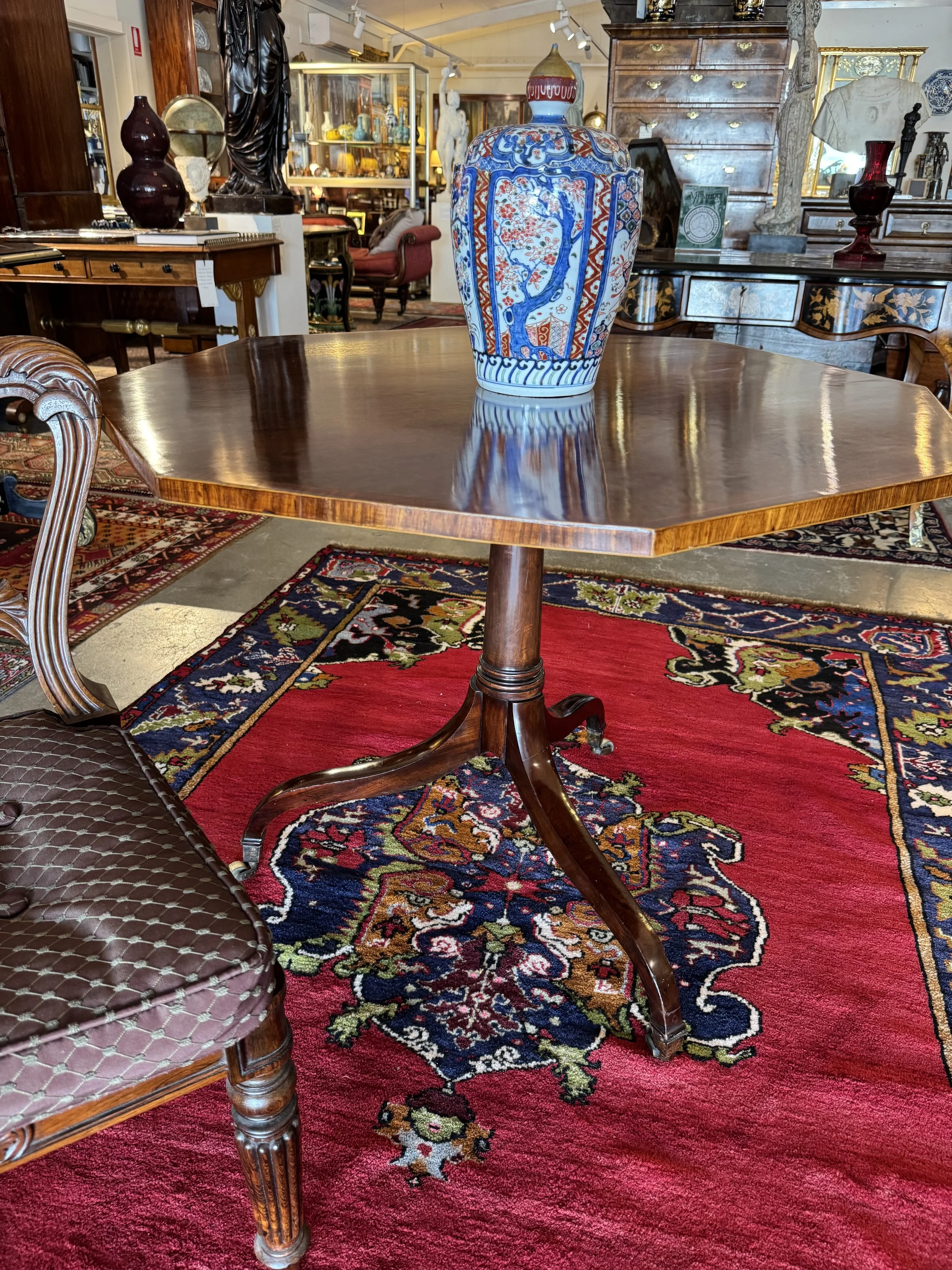 This is a picture of a superb English antique George III period octagonal plum pudding mahogany and rosewood cross banded centre table c1790.