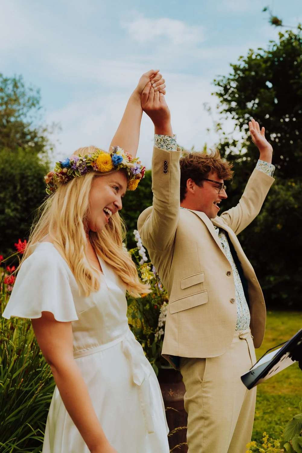 bride and groom hands in the air at the end of their wedding ceremony