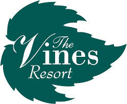 Logo for The Vines Resort featuring a stylized green leaf design with the resort name in white script