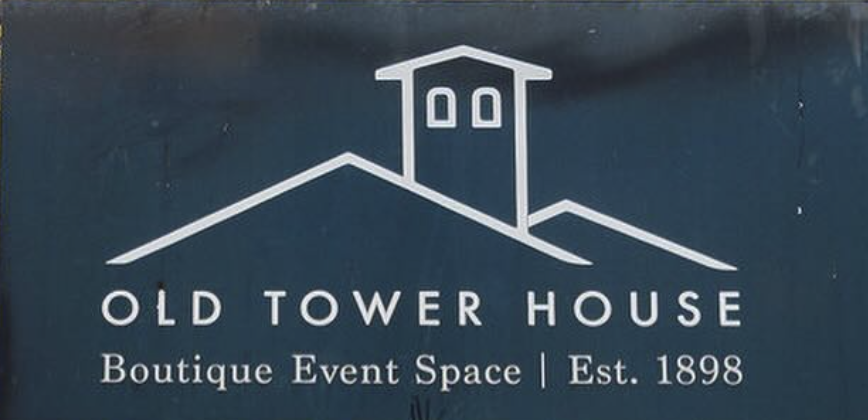 Sign for Old Tower House, a boutique event space established in 1898, with an illustration of a tower house on a hill.