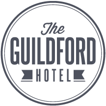 Logo for The Guildford Hotels with a circular black background and gray text.