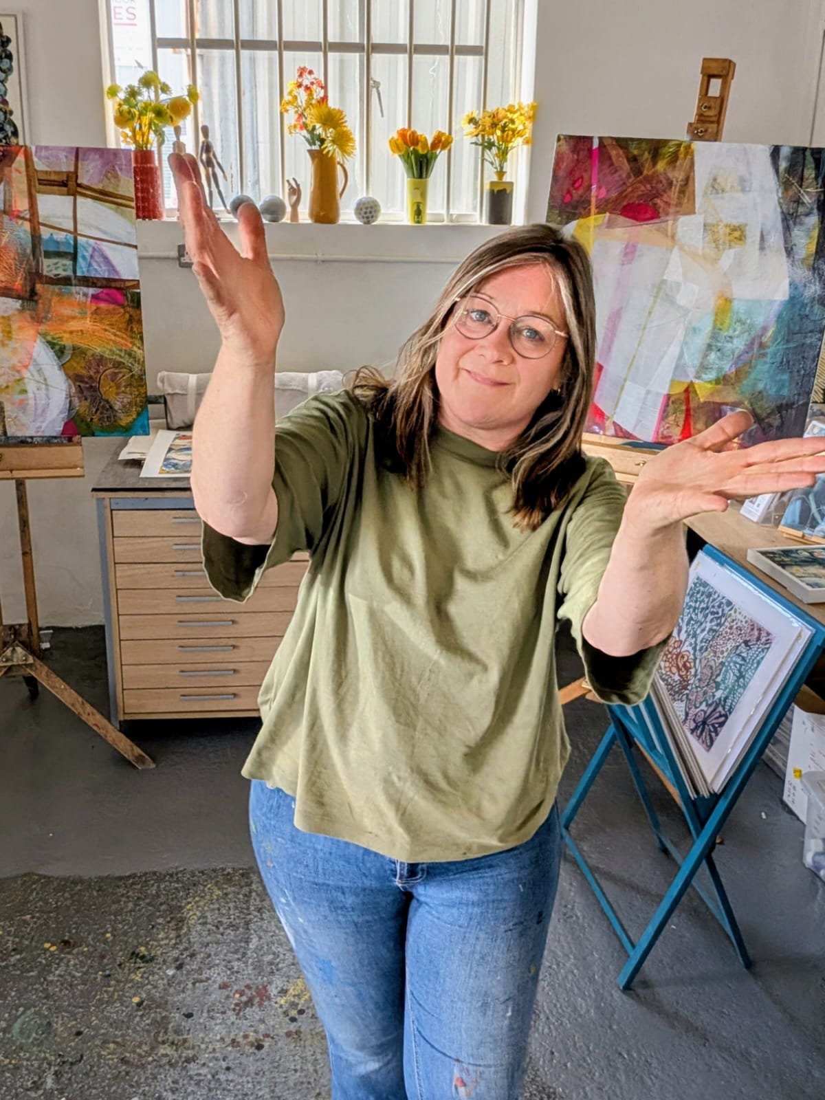 Jo Morley in a green t-shirt, happy in her beautiful art studio in Southampton