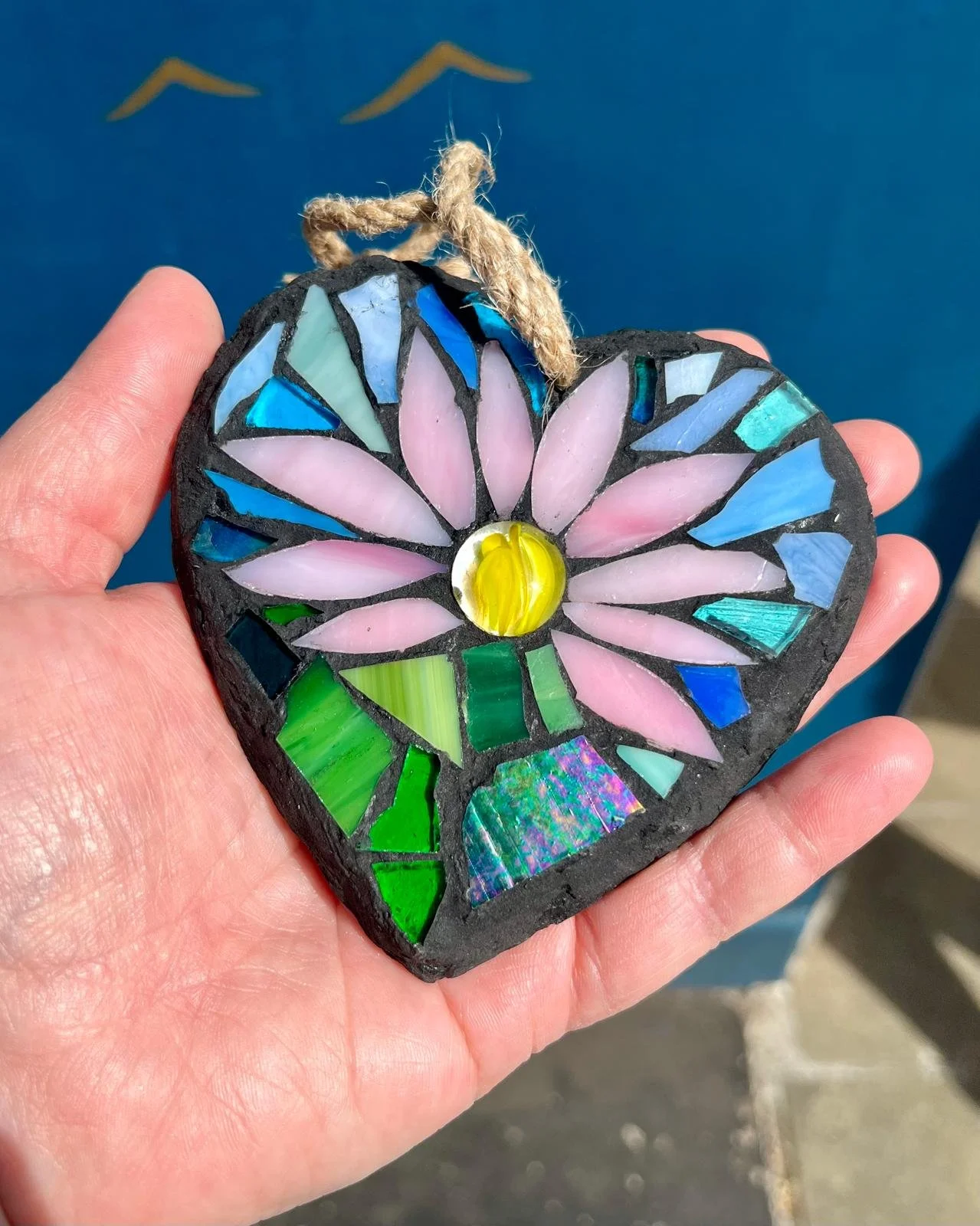 A hand holding a heart shapes mosaic