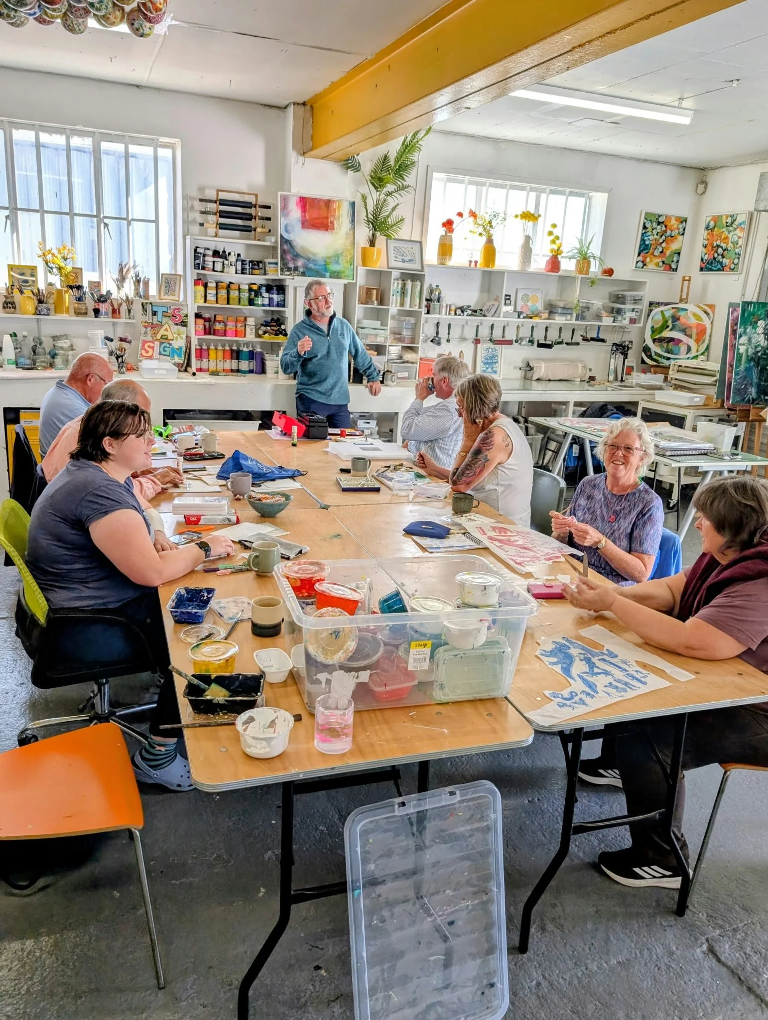 a group fo people around a table smiling and being creative