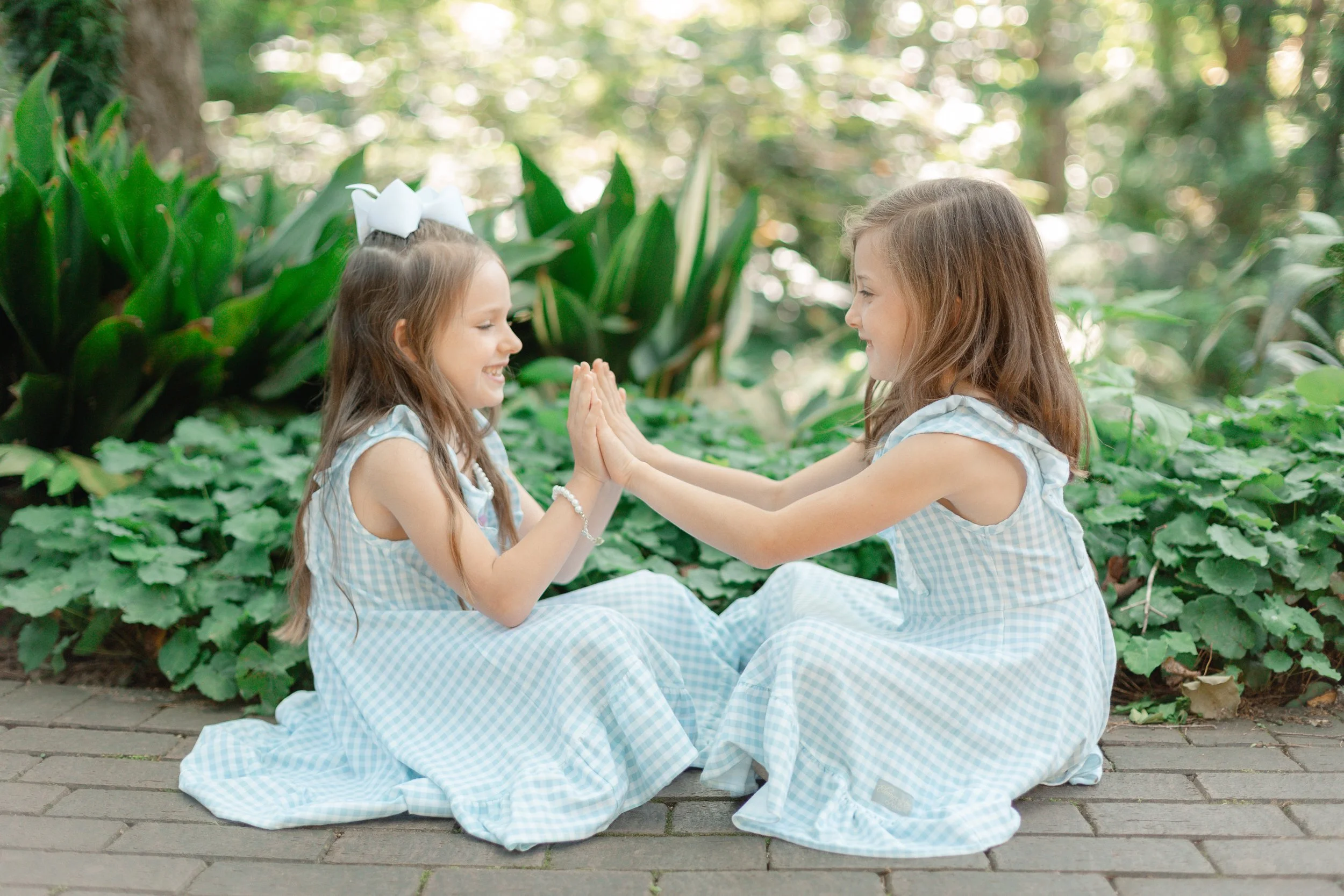 Two young girls holding hands for photoshoot in garden in Clemson SC