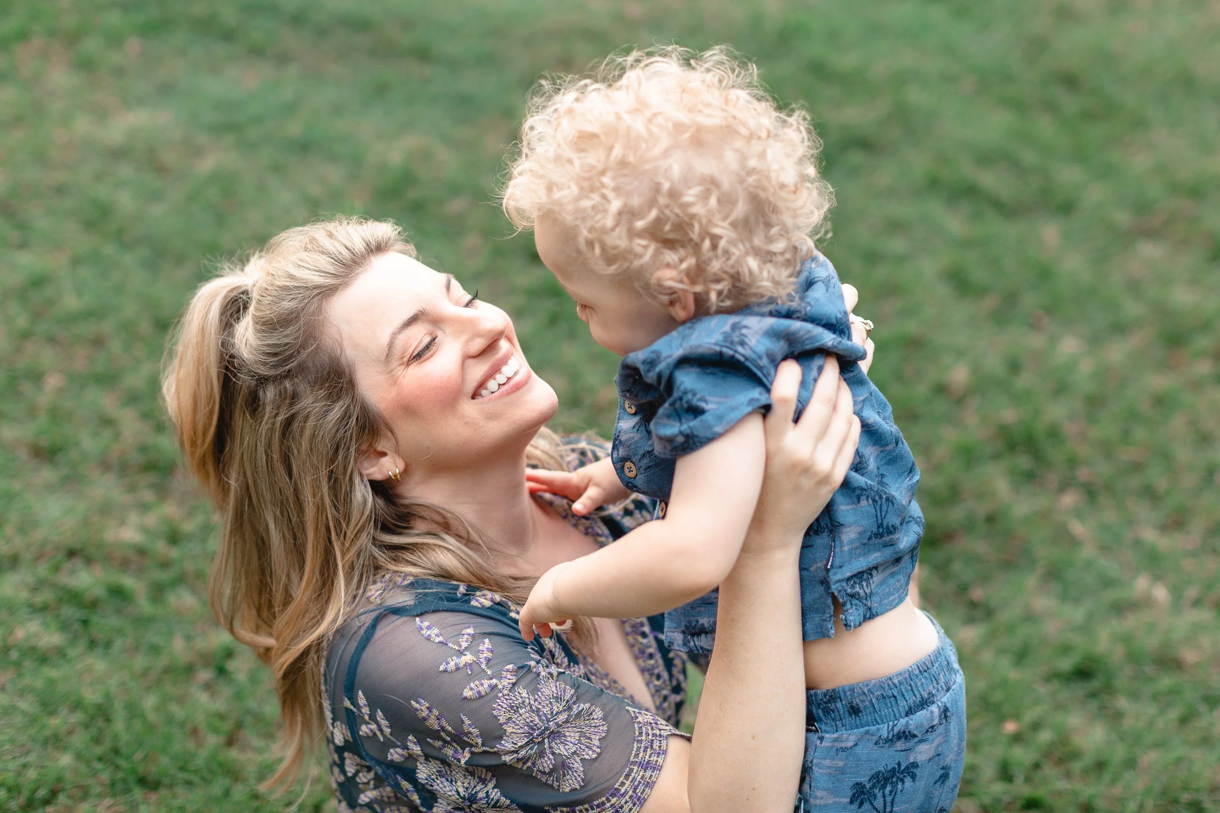 Mother holding toddler son and smiling during natural light photo session in Clemson, SC