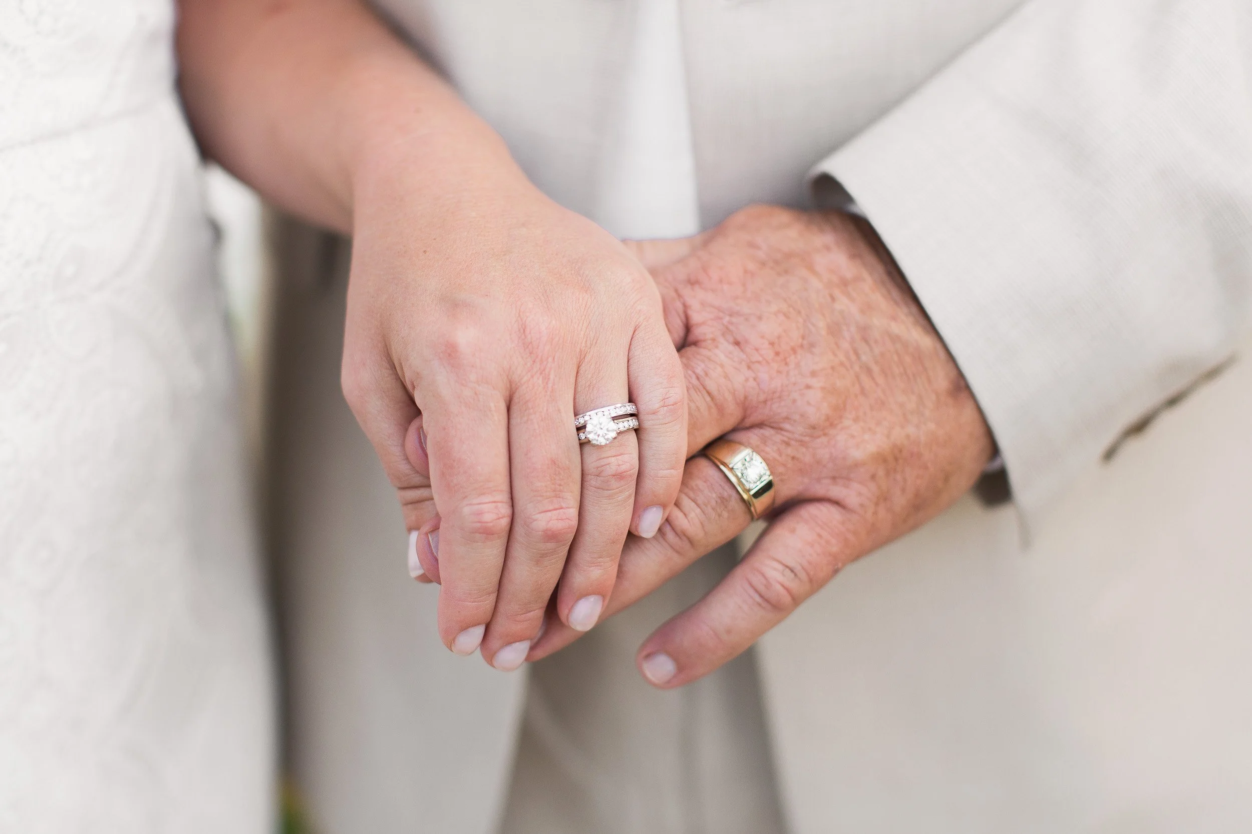 Close-up of two people holding hands, one with a wedding ring during intimate wedding ceremony in Clemson, SC