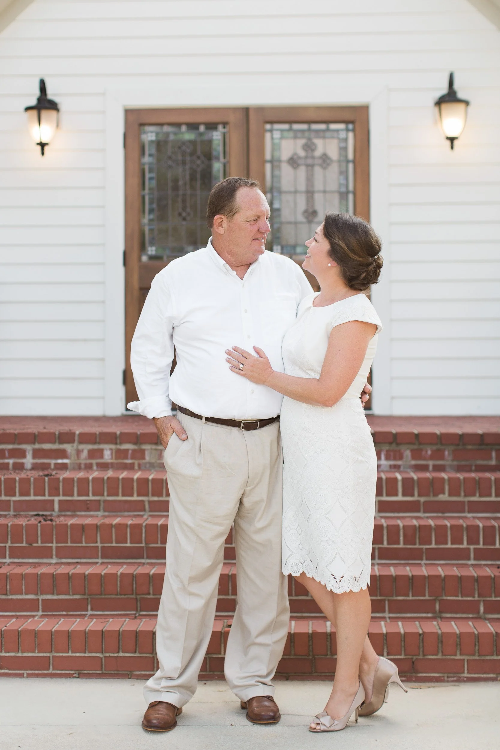 A middle-aged man and a woman stand close together in front of a church during intimate wedding ceremony in Greenville, SC