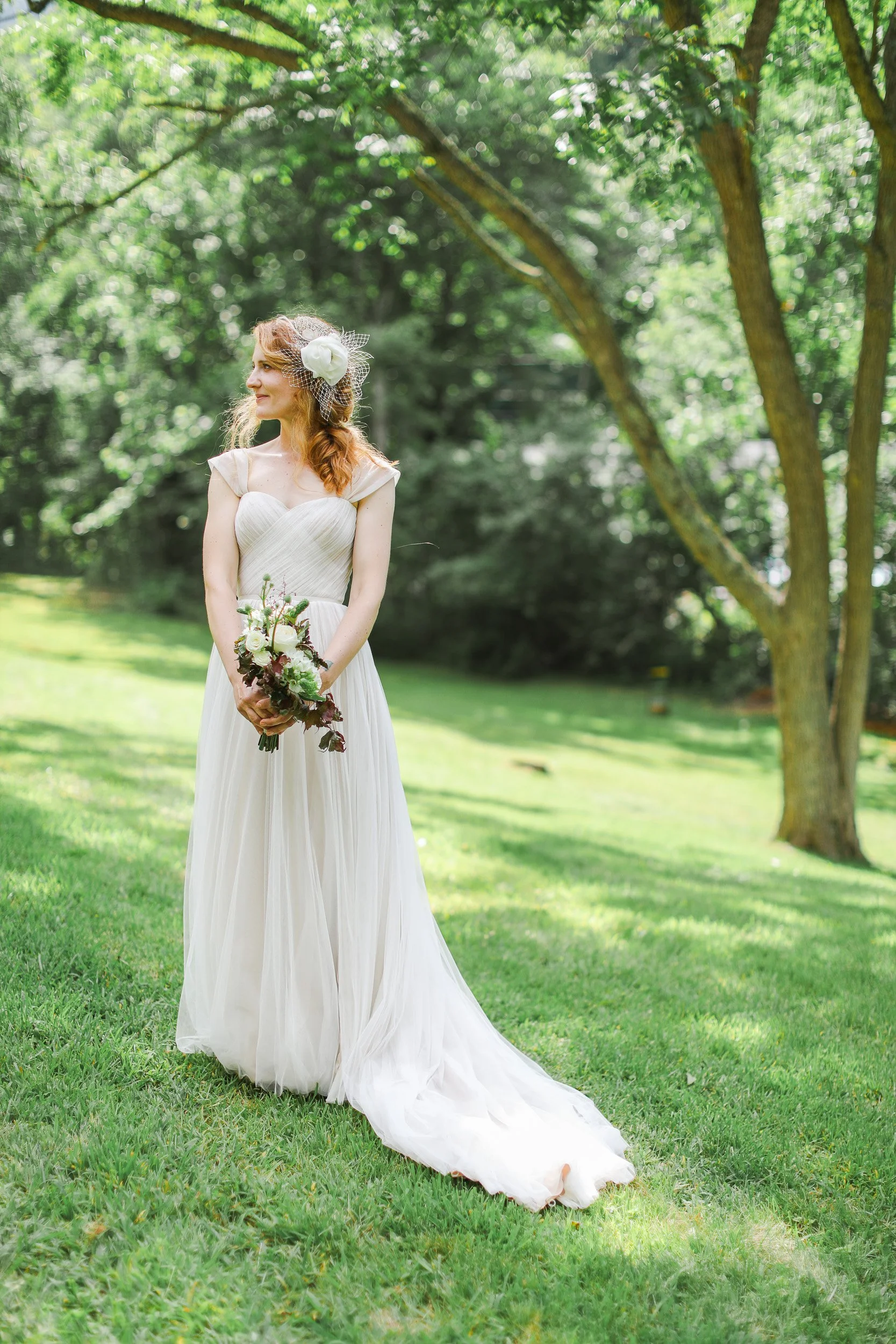 A bride in a white wedding dress holding a bouquet outdoors at small wedding in Travelers Rest, SC