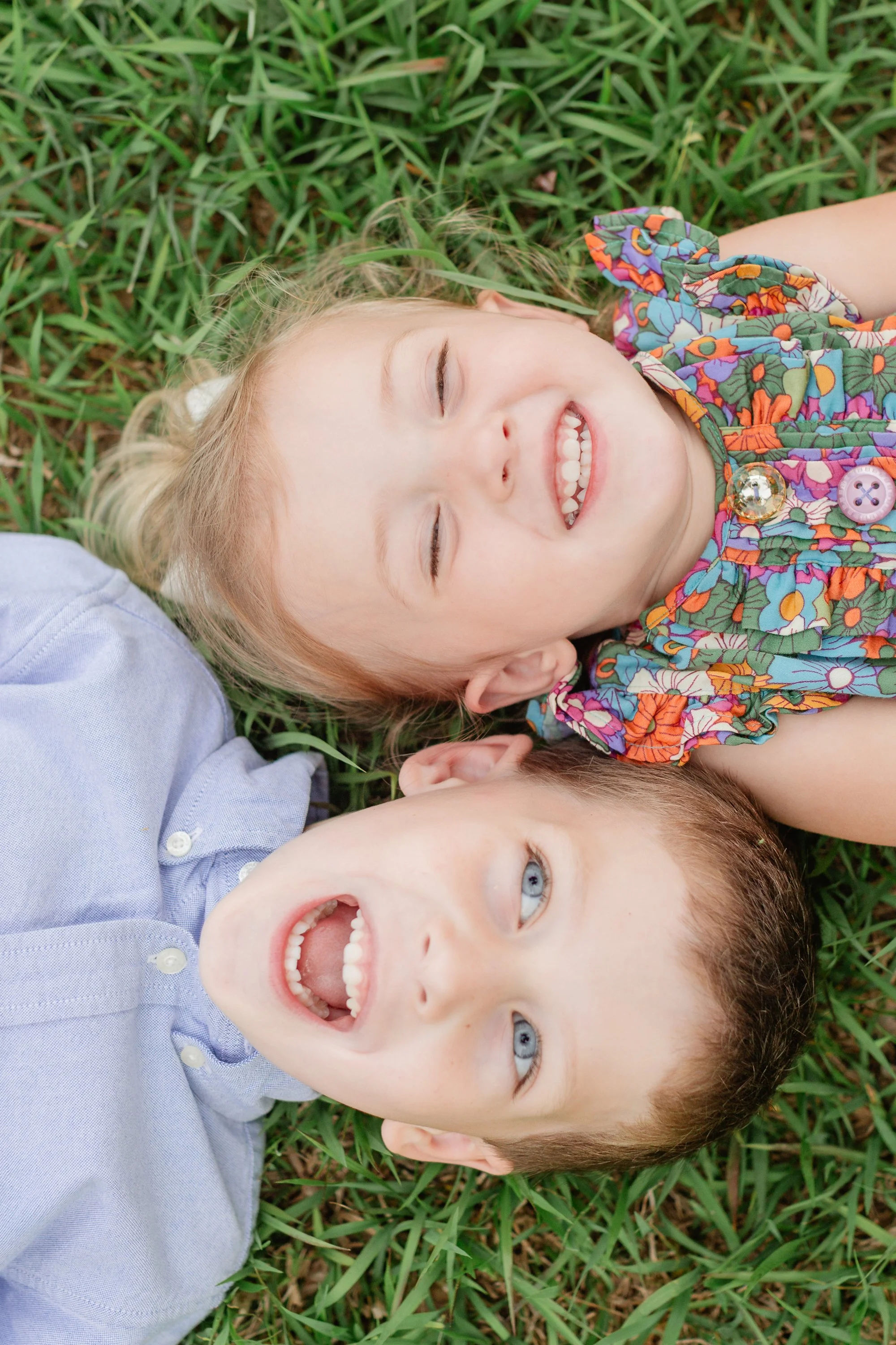 Little girl and boy laying on ground laughing during photoshoot in Clemson South Carolina
