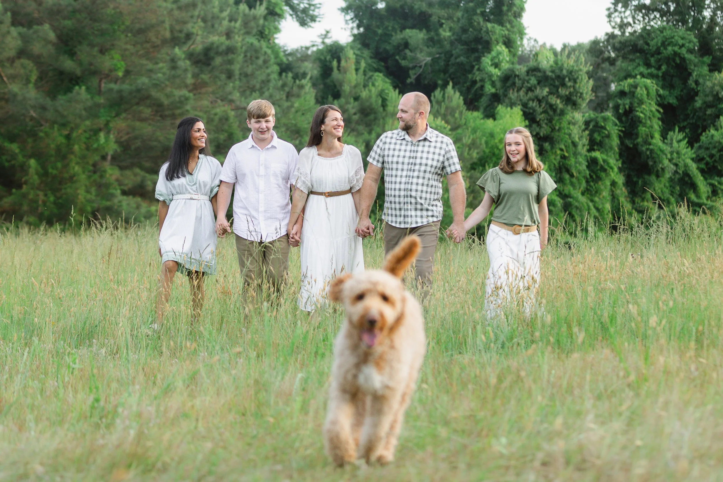 Family of five holding hands during natural light photo session in Clemson, South Carolina