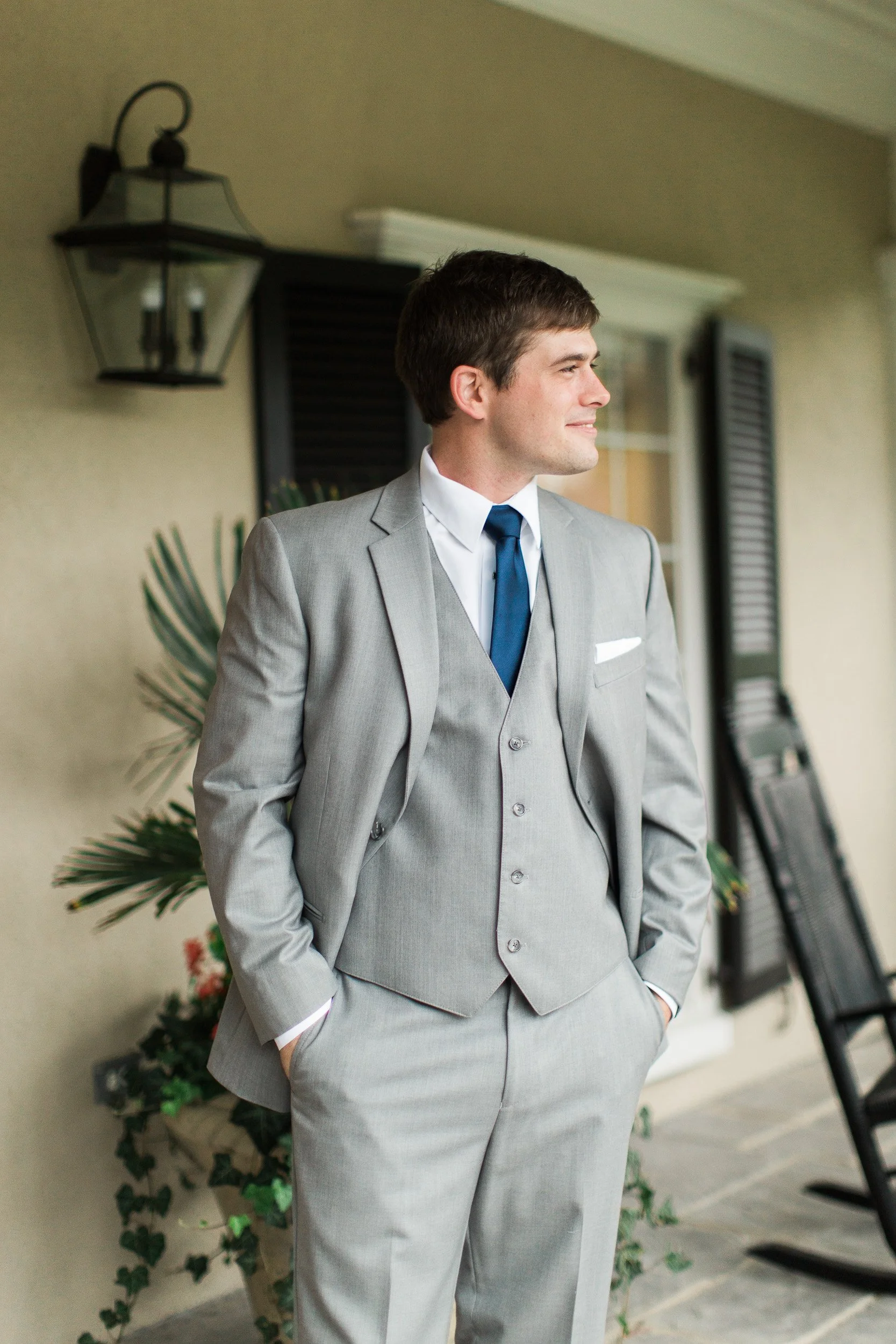 A  groom in a gray suit posing before intimate wedding at Lake Keowee in South Carolina