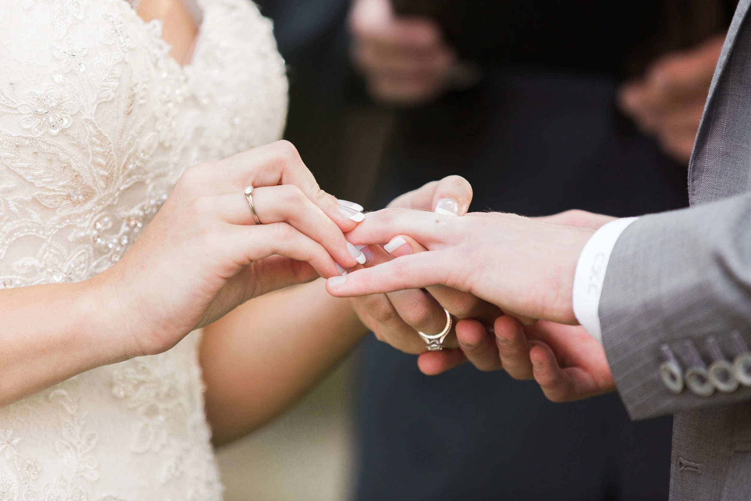 A bride and groom exchanging wedding rings with the bride placing a ring on the groom's finger during intimate wedding at Lake Keowee in South Carolina