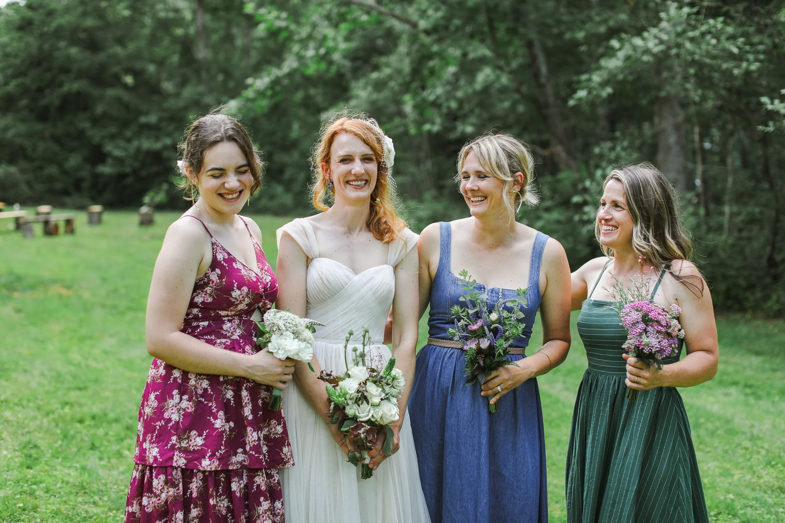 Four women standing outdoors on grass during small wedding in Greenville, SC