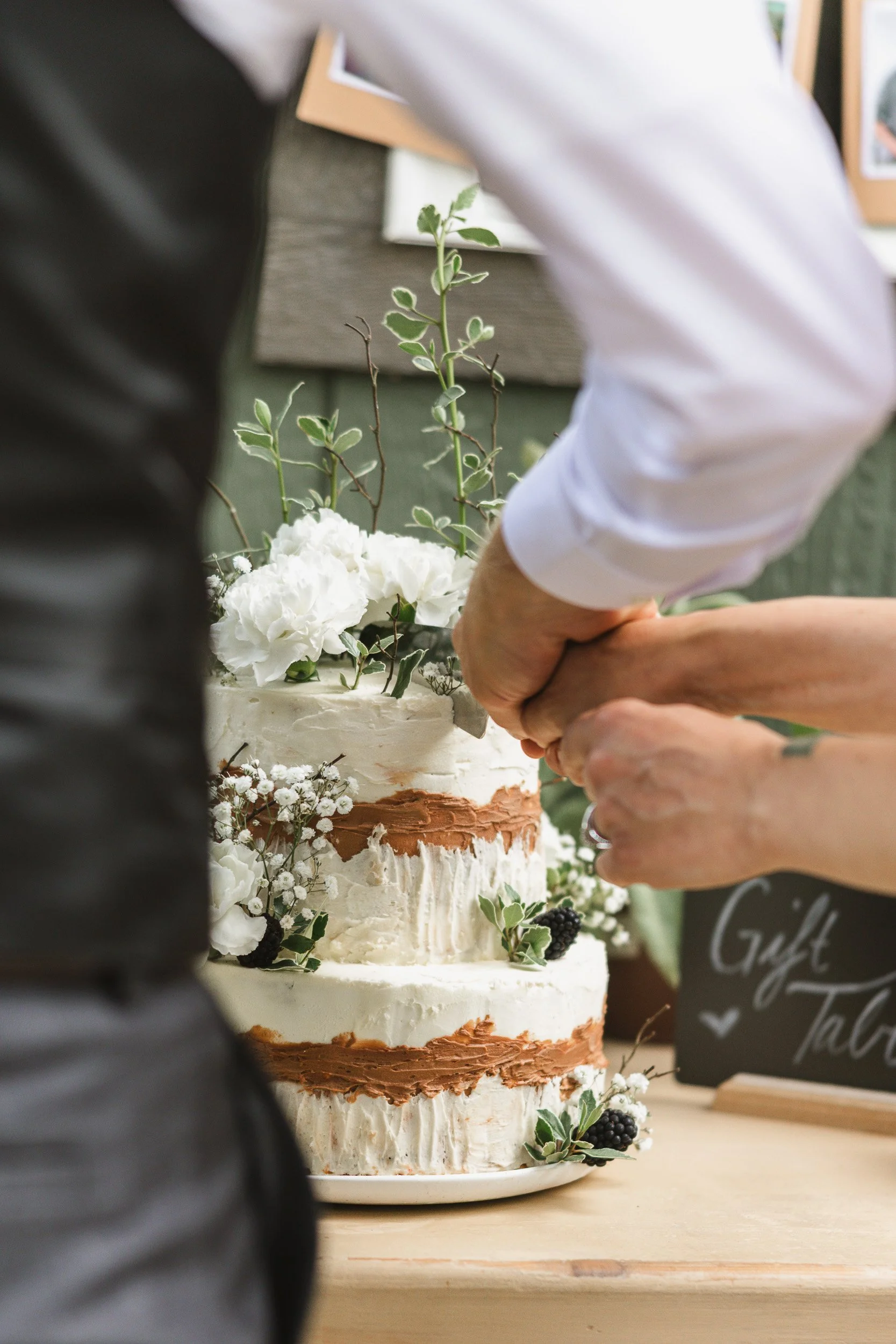 Close-up of bride and groom cutting cake at intimate outdoor wedding ceremony in Clemson, SC