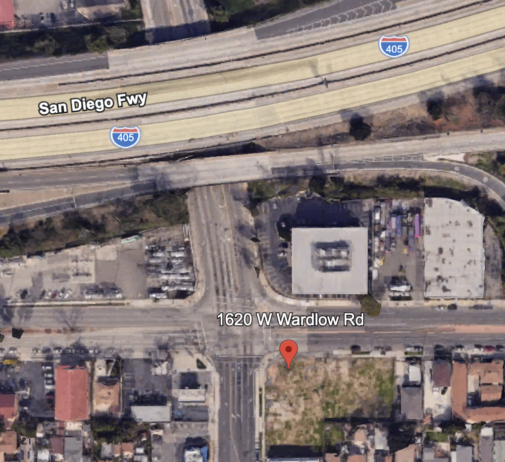 Satellite view of a highway interchange with the label 'San Diego Fwy' and the interstate '405'. Below, a street labeled '1620 W Wardlow Rd' intersects the area, with surrounding buildings and residential houses visible.
