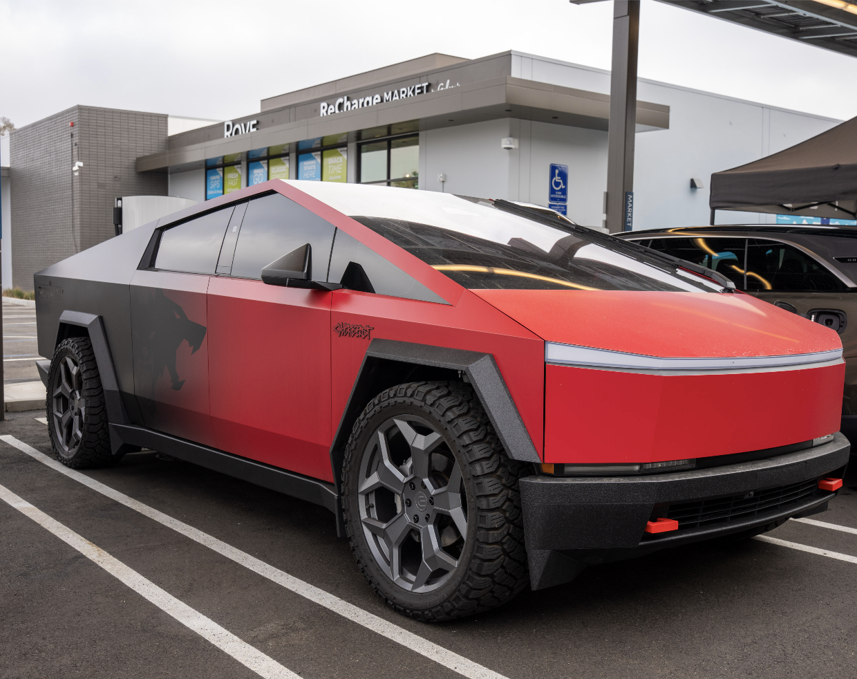 Red and black cyber truck charging at Rove in Costa Mesa