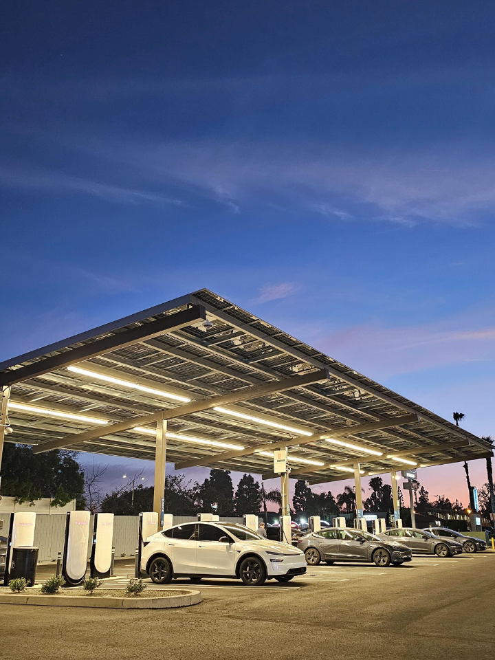 Rove Costa Mesa Charging Area with a white Tesla and a dusk sky in the background