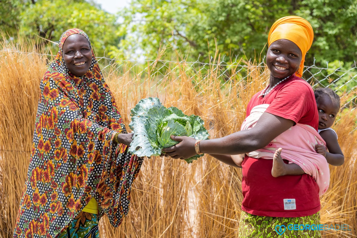 Smiling community members near a clean water project
