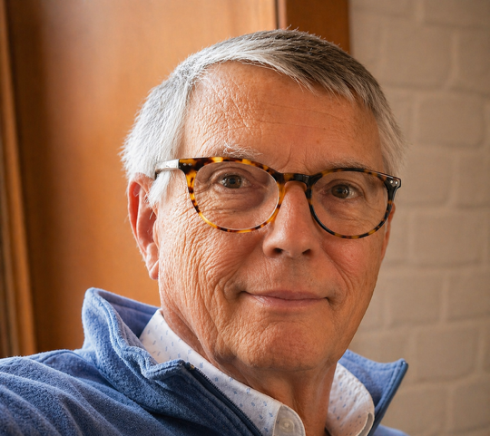 Image of Buddy Swain, a white man with white hair and glasses.