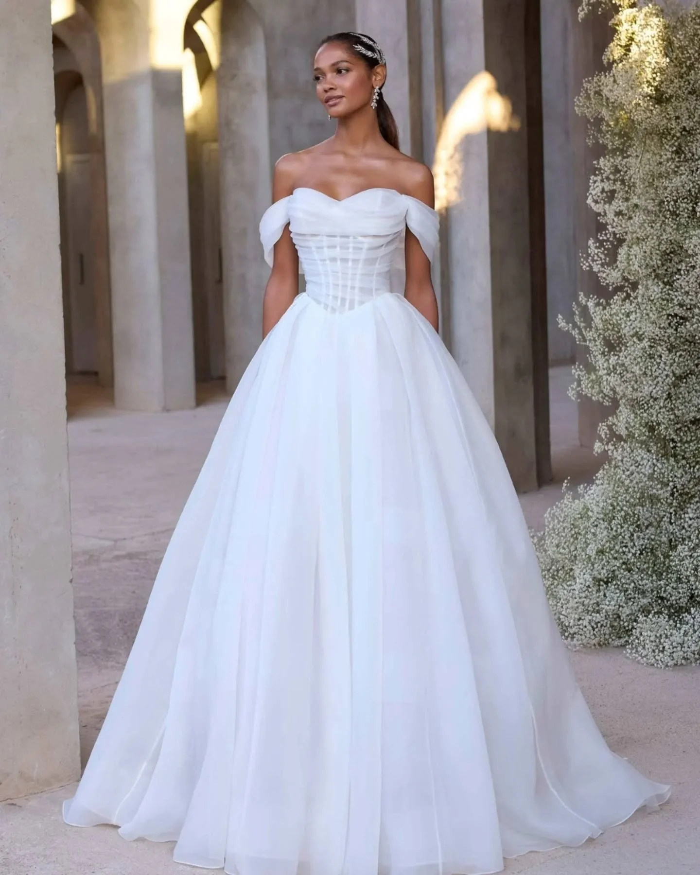 Mori Lee 2947&nbsp;🤍

&nbsp;

Een romantische bruidsjurk met een gestructureerde corset top en off-shoulder mouwen die je taille perfect accentueren. De volle rok met sleep en knoopjesrij achter maken dit een jurk die indruk maakt.

&nbsp;

Benieuwd