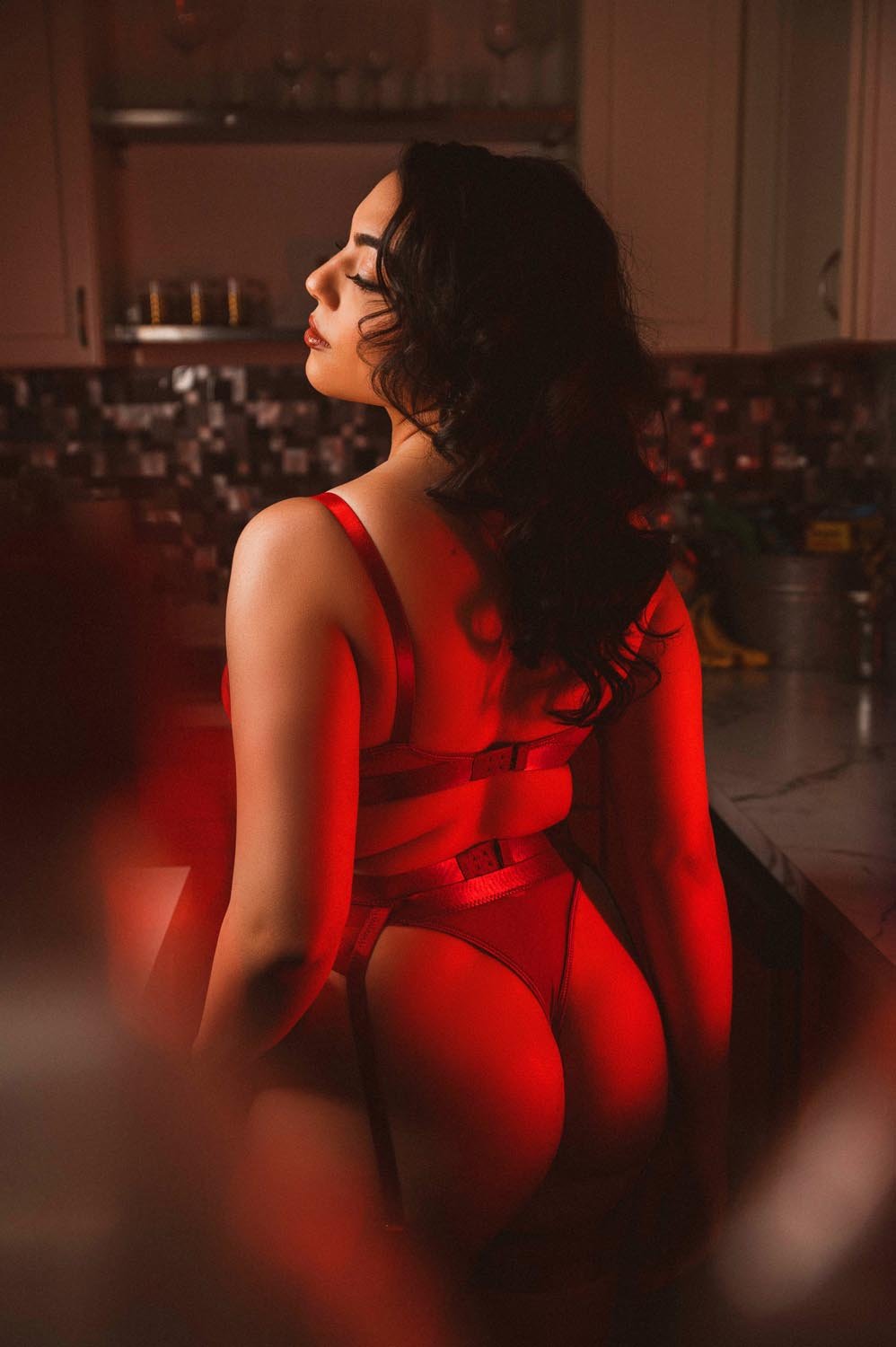 We photographed a moody red lingerie scene with a Middle Eastern woman with a red light glowing down her back.