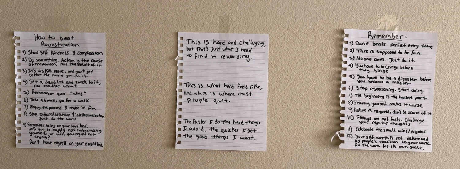 Three sheets of paper taped to a wall containing reminders and motivational quotes.
