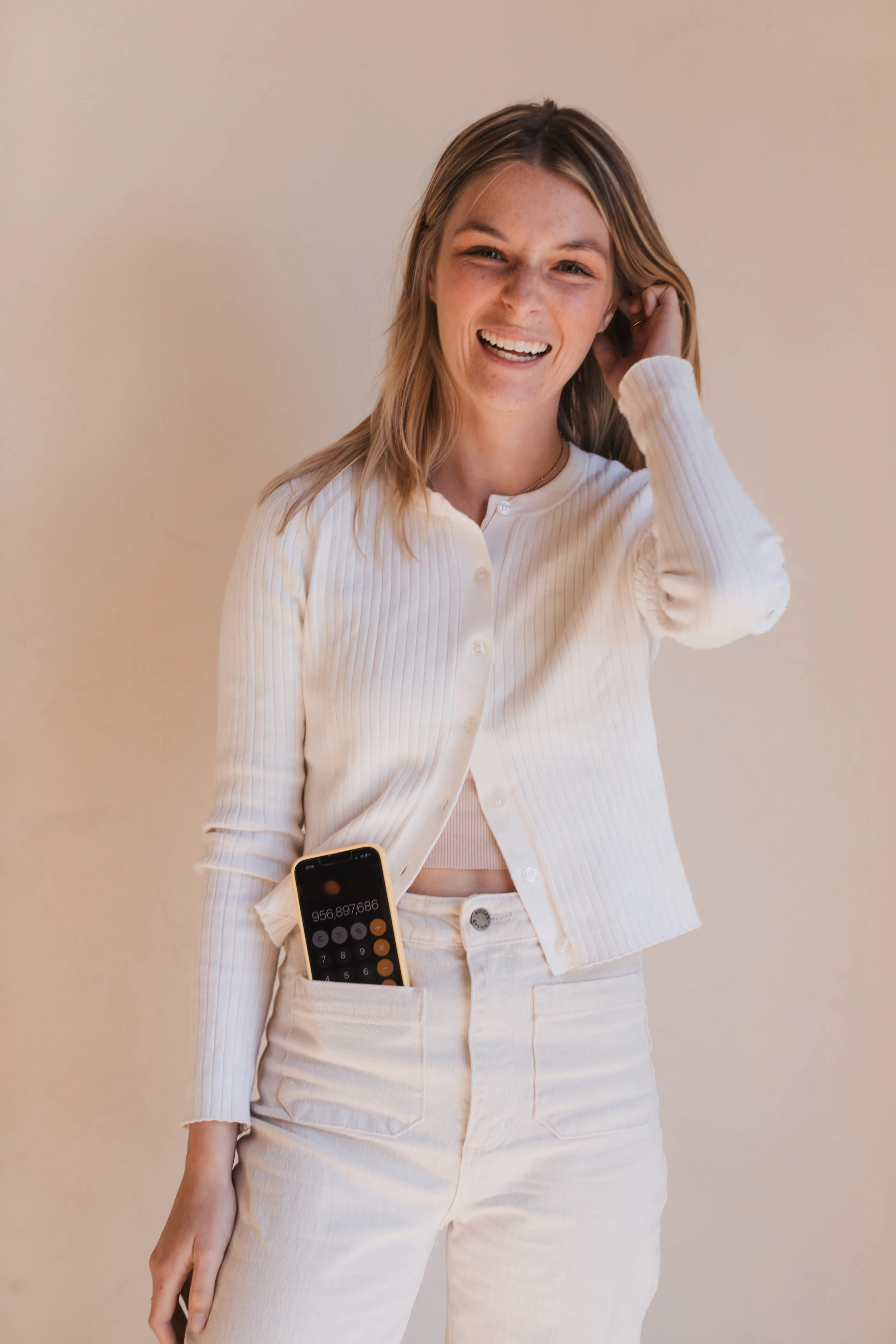 Delaney from Carefully Counted with a phone in her pocket showing a calculator.