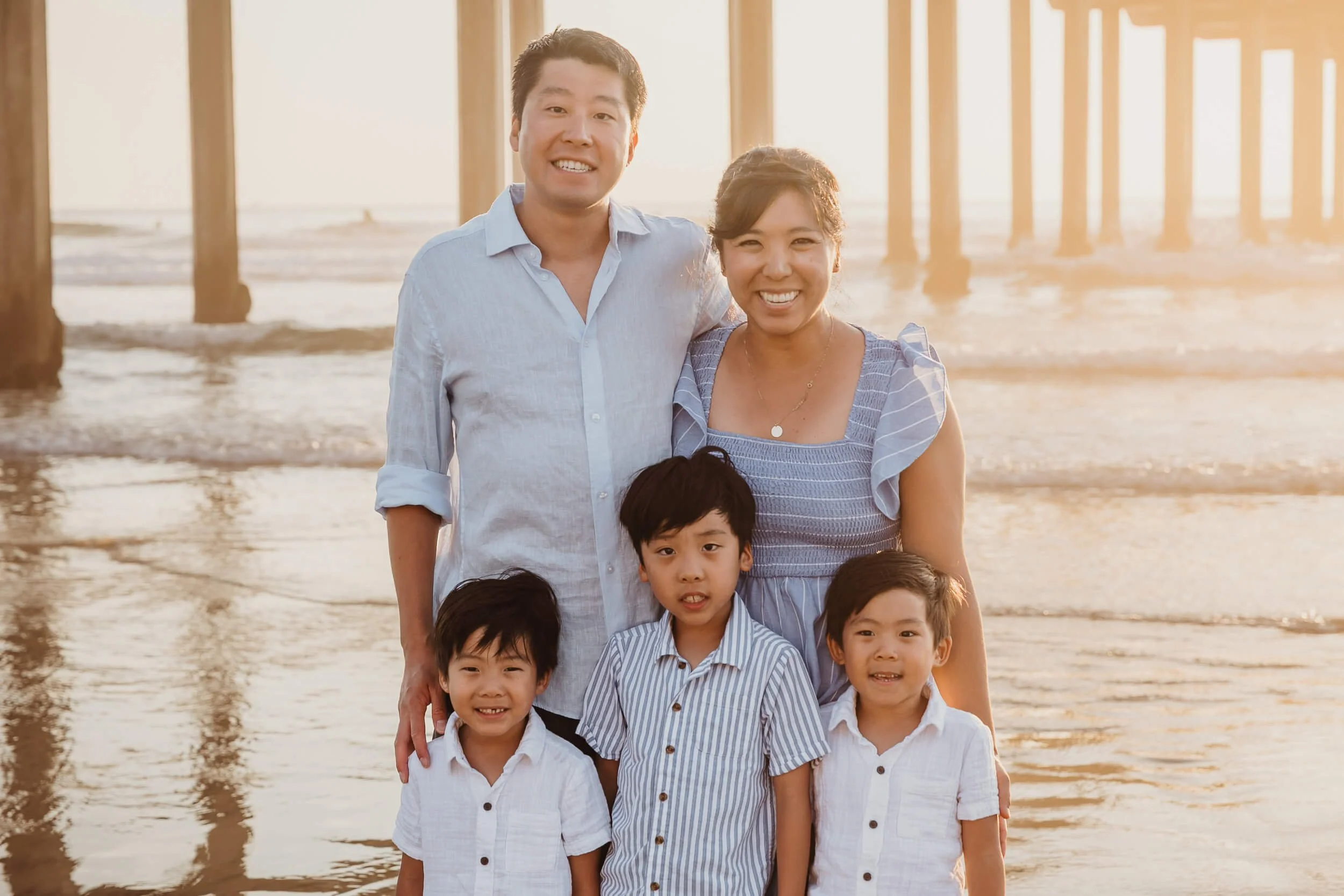 Family of five during golden hour sunset session at La Jolla Shores with Scripps pier in the background 