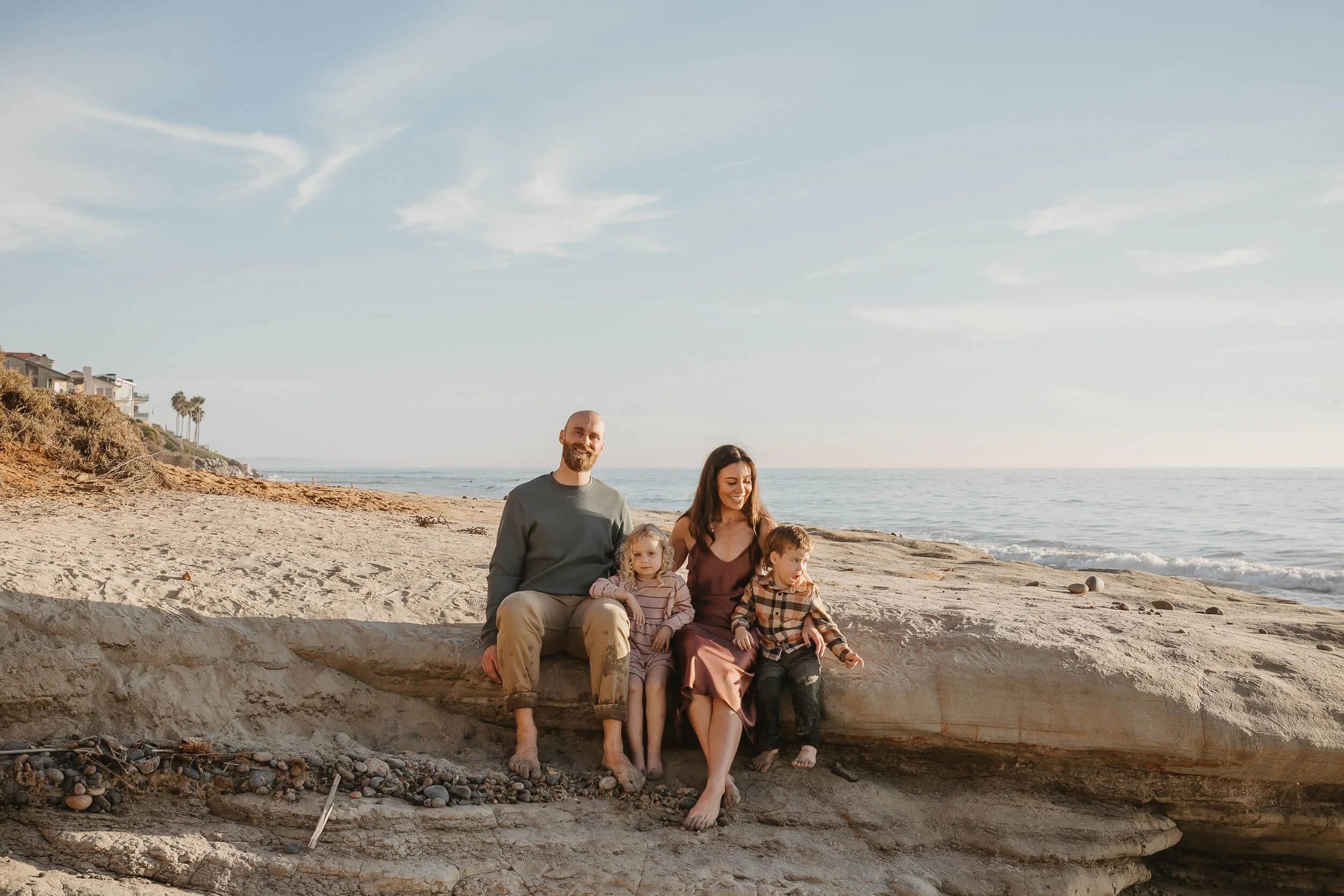 Relaxed family portrait by the ocean in Carlsbad, California during golden hour