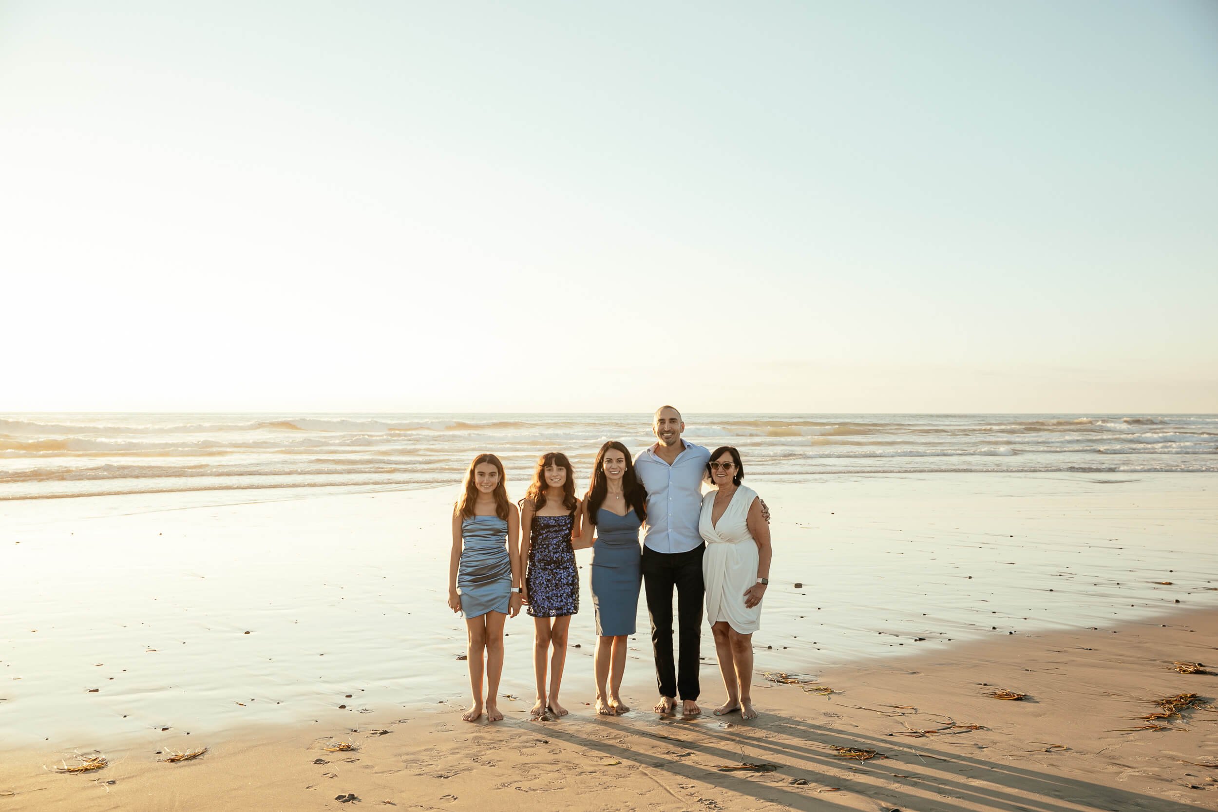 Family walking along the beach during golden hour in Carlsbad, California
