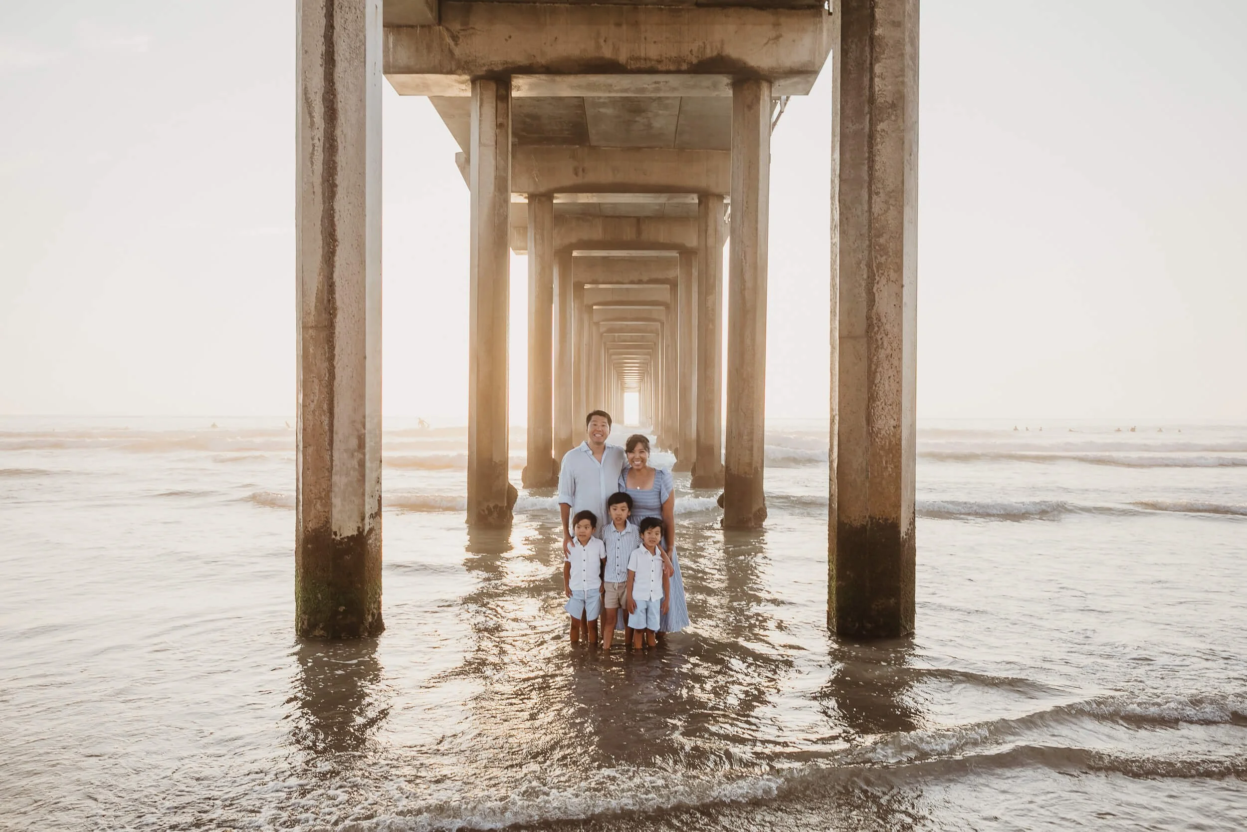Family under Scripps Pier for San Diego family photography session at La Jolla Shores Beach 
