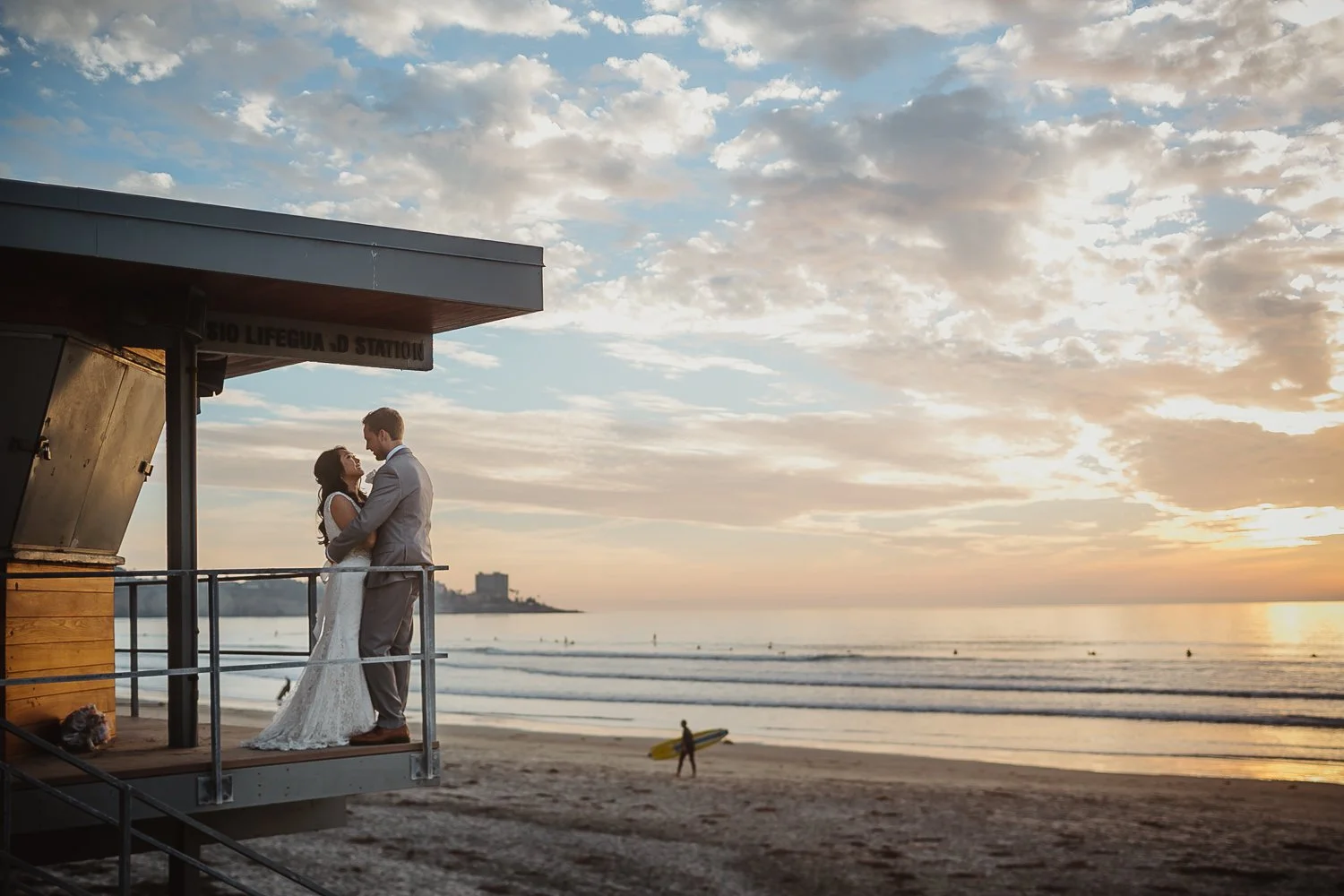 Couple looking at each other at La Jolla Shores Beach on Lifeguard tower for wedding photography session
