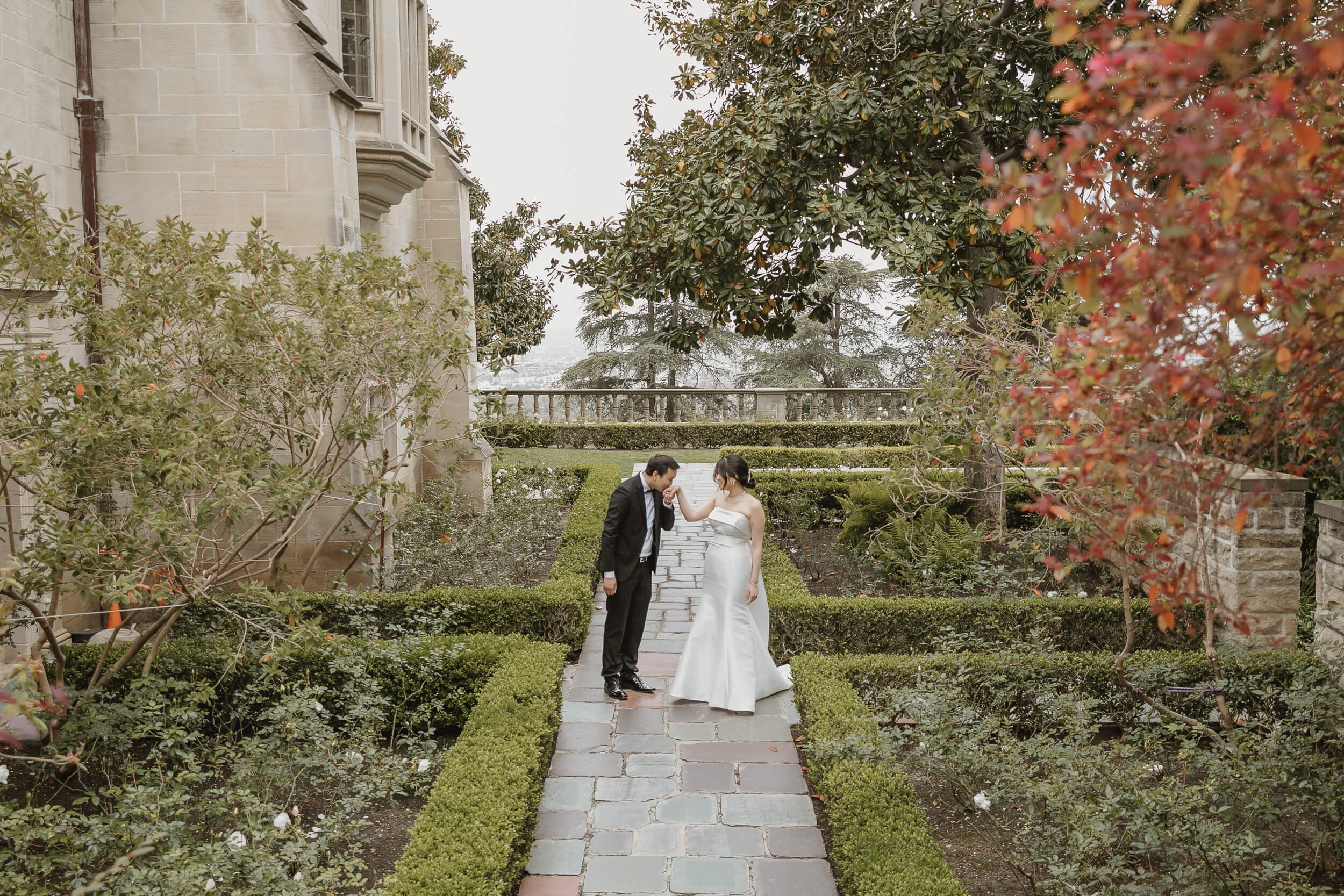 Groom kissing bride's hand at Greystone Mansion and Gardens in Beverly Hills during engagement portrait session