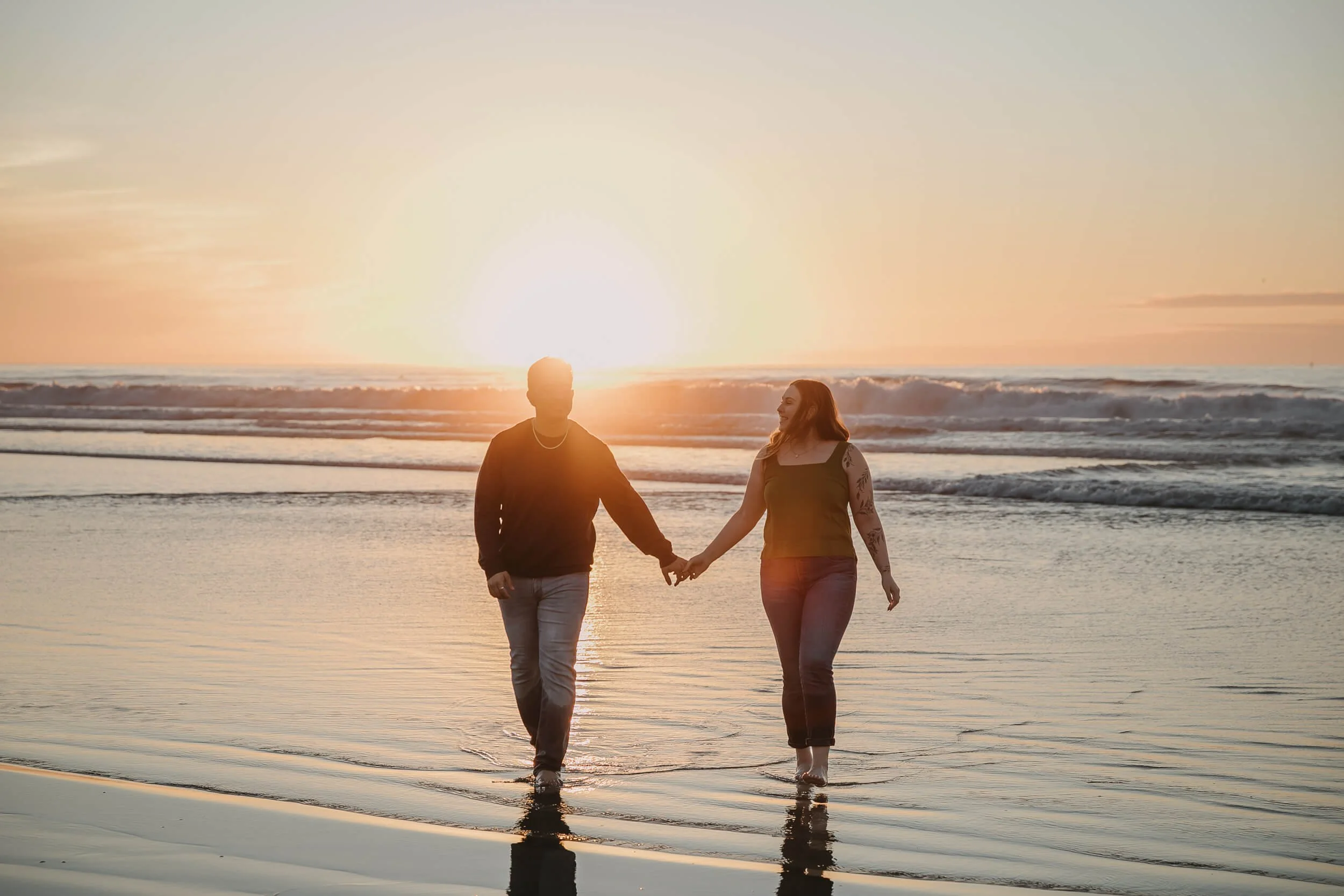 Couple walking and looking at each other during La Jolla Shores engagement session looking at each other