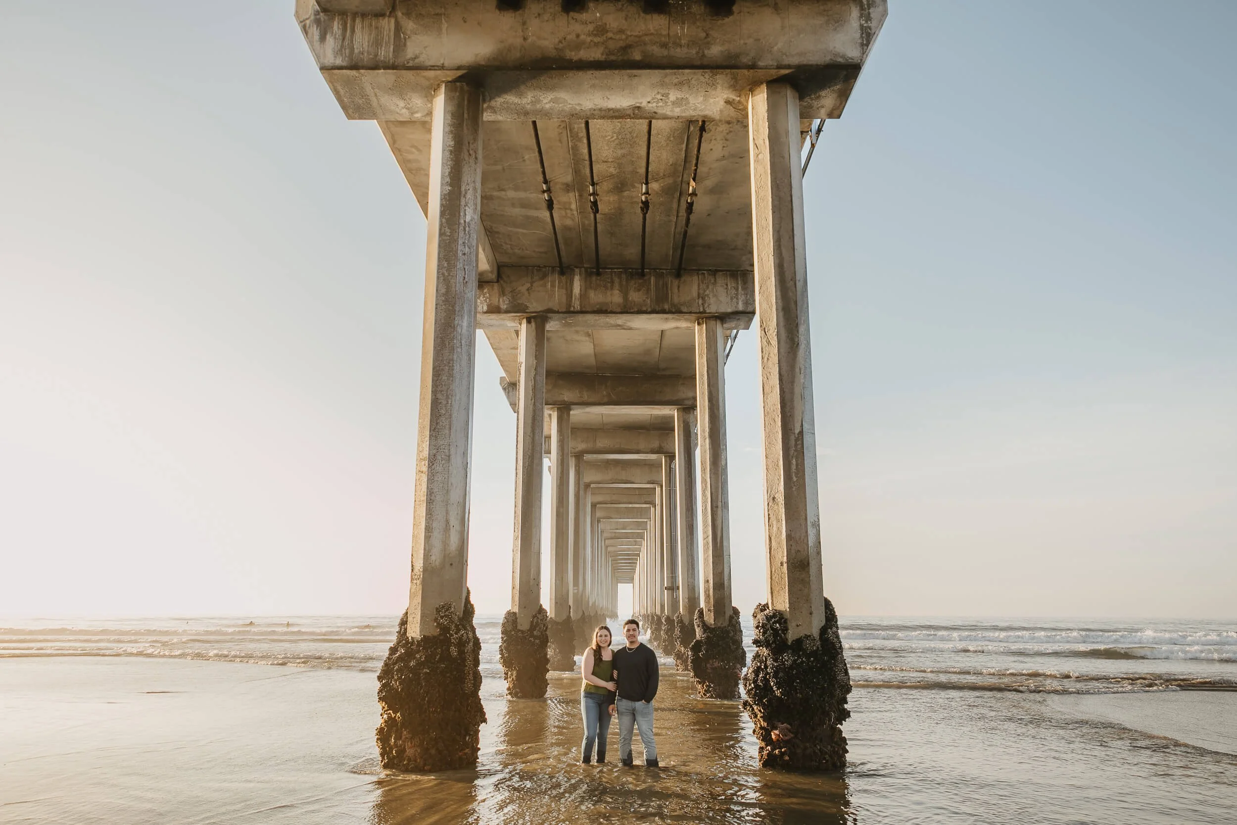 San Diego photography mini session wide photo of couple under Scripps Pier in La Jolla Shores