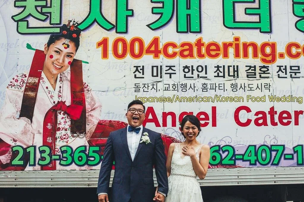 Fun portrait bride and groom laughing really hard in front of Korean food truck outside Luce Loft wedding reception